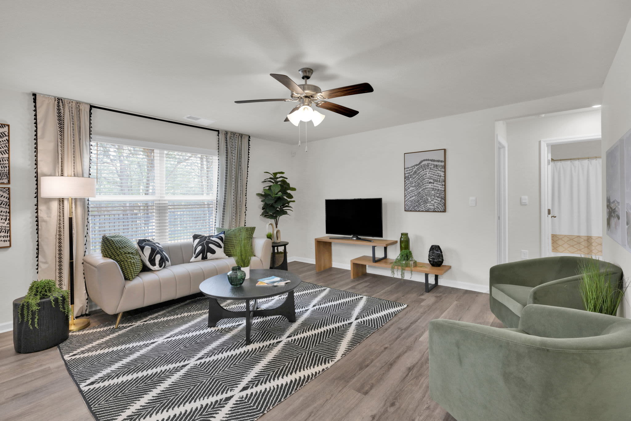 Spacious living room with large comfortable couches, tv and ceiling fan at Miller Landing in Cleveland, Tennessee