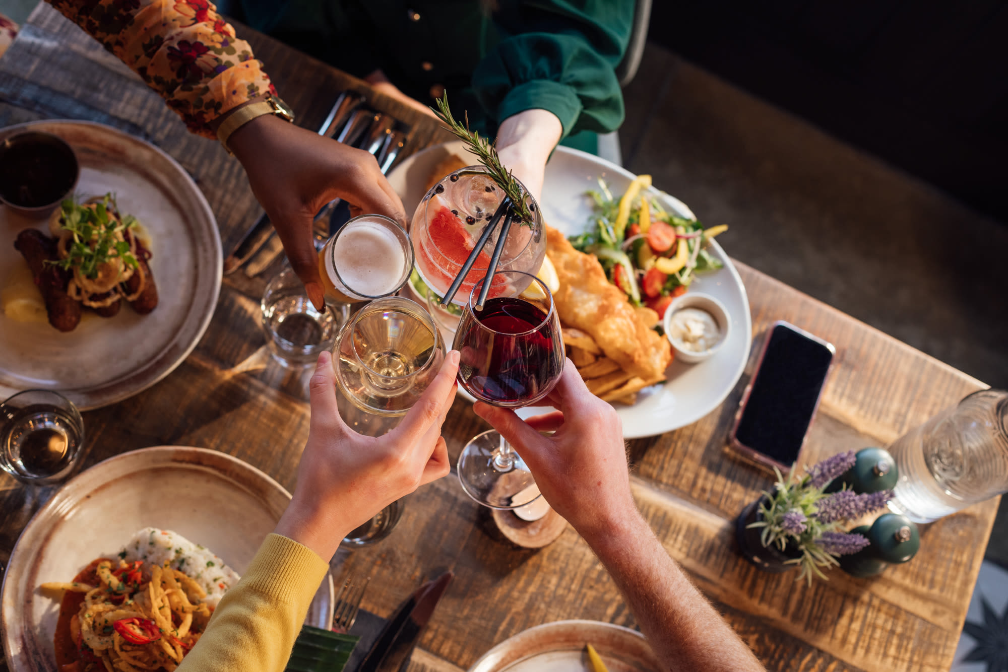 A group of friends toasting glasses near Urban House in Dallas, Texas