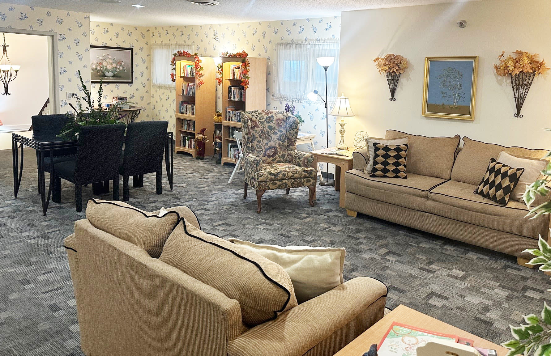 A resident living room with a couch, a chair and a table at HeatherWood Assisted Living & Memory Care in Eau Claire, Wisconsin. 