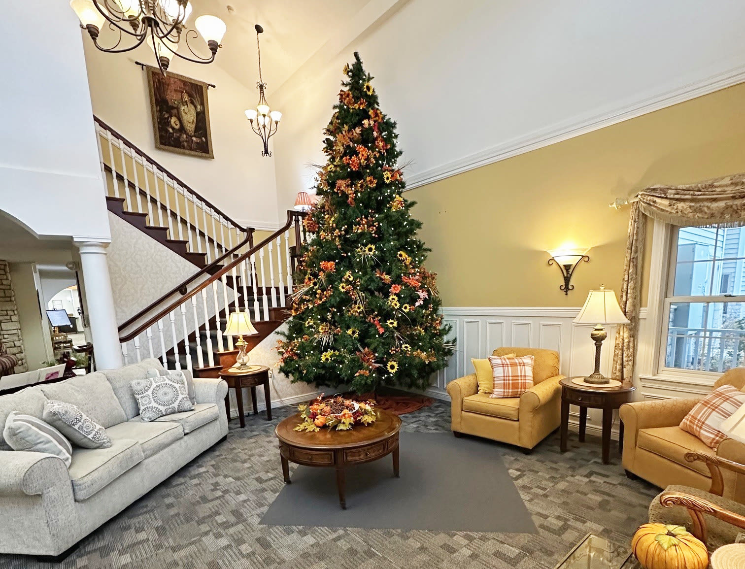 Living room with a Christmas tree and comfortable couches at HeatherWood Assisted Living & Memory Care in Eau Claire, Wisconsin. 