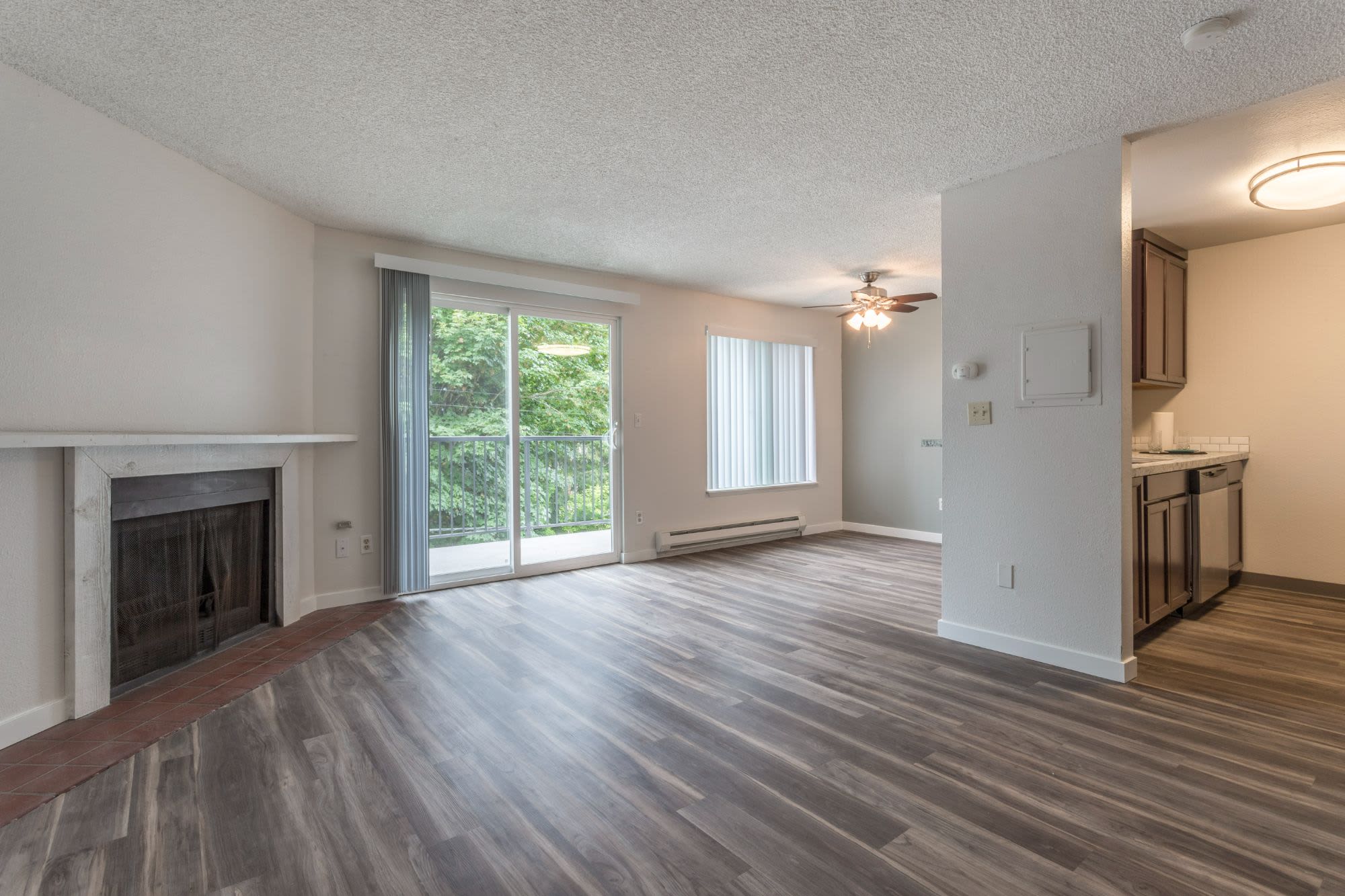 Thoughtfully designed living room with wood flooring and fireplace at Solana Apartments in Burien, WA at Solana Apartments in Burien, Washington