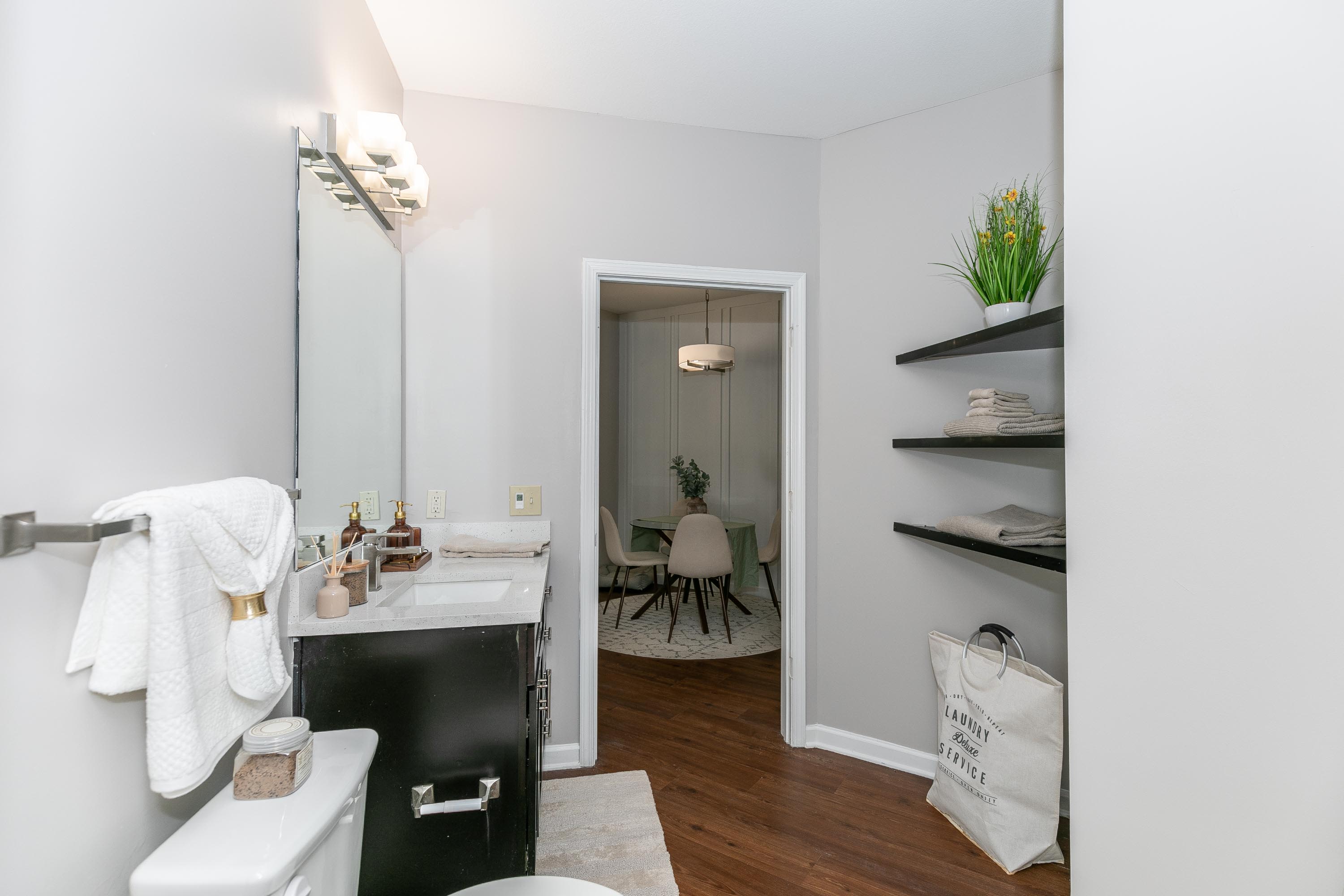 A Modern Bathroom with a toilet, sink, and functional shelves at Thomaston Crossing in Macon, Georgia