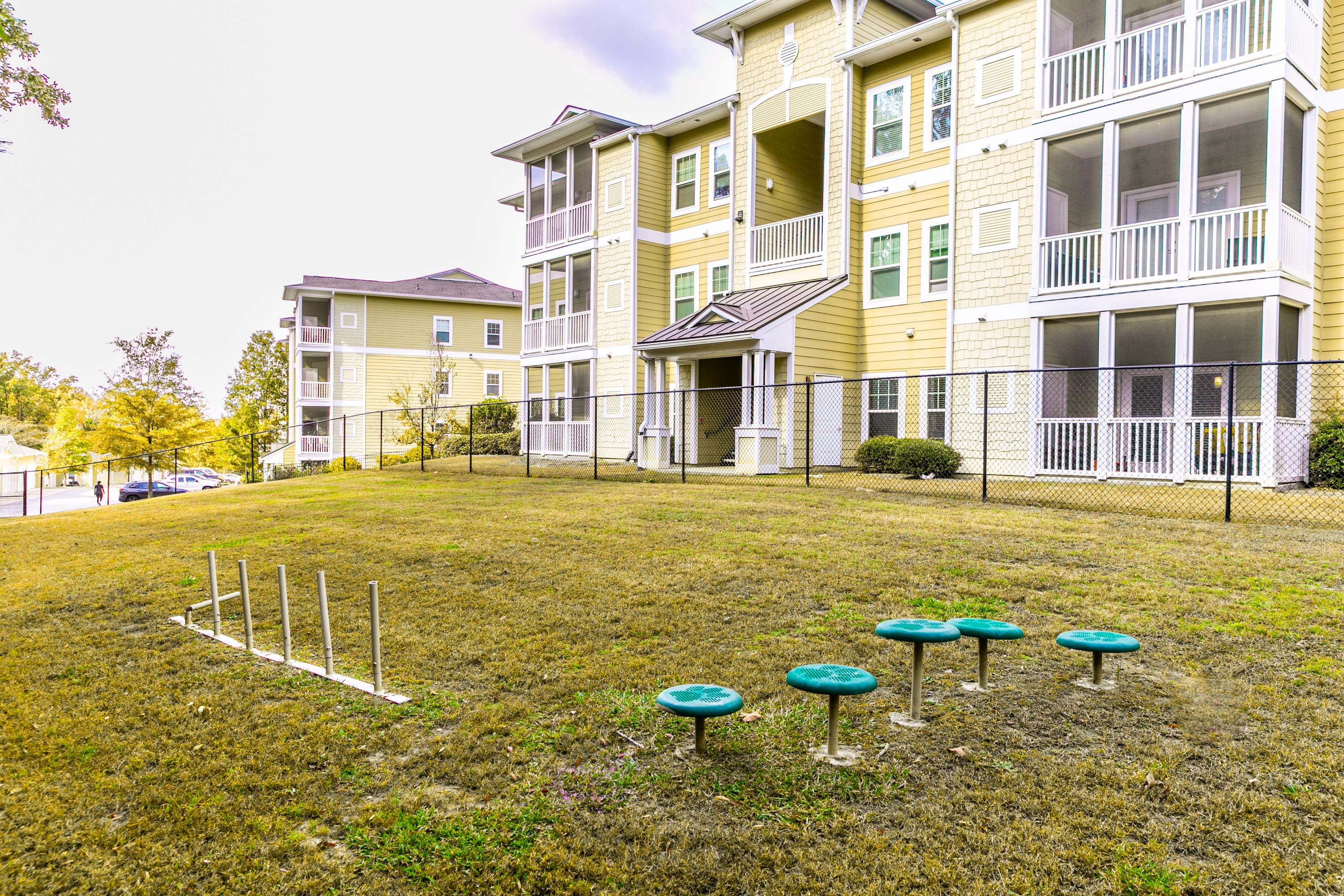 A well-maintained lawn with an assortment of lawn games located in front of an apartment complex at Thomaston Crossing in Macon, Georgia