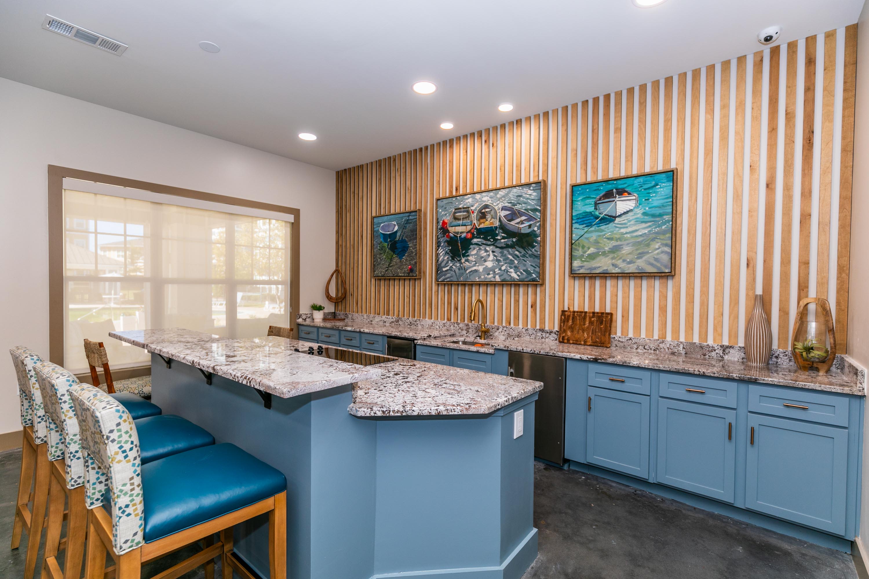 A modern kitchen design with blue chairs and a bar at Thomaston Crossing in Macon, Georgia
