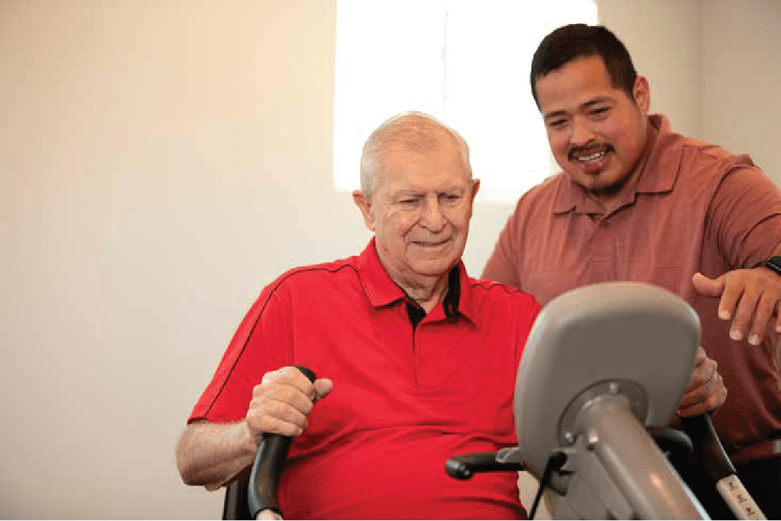 resident getting assistance with an excercise bike at Clearwater Beaverton in Beaverton, Oregon
