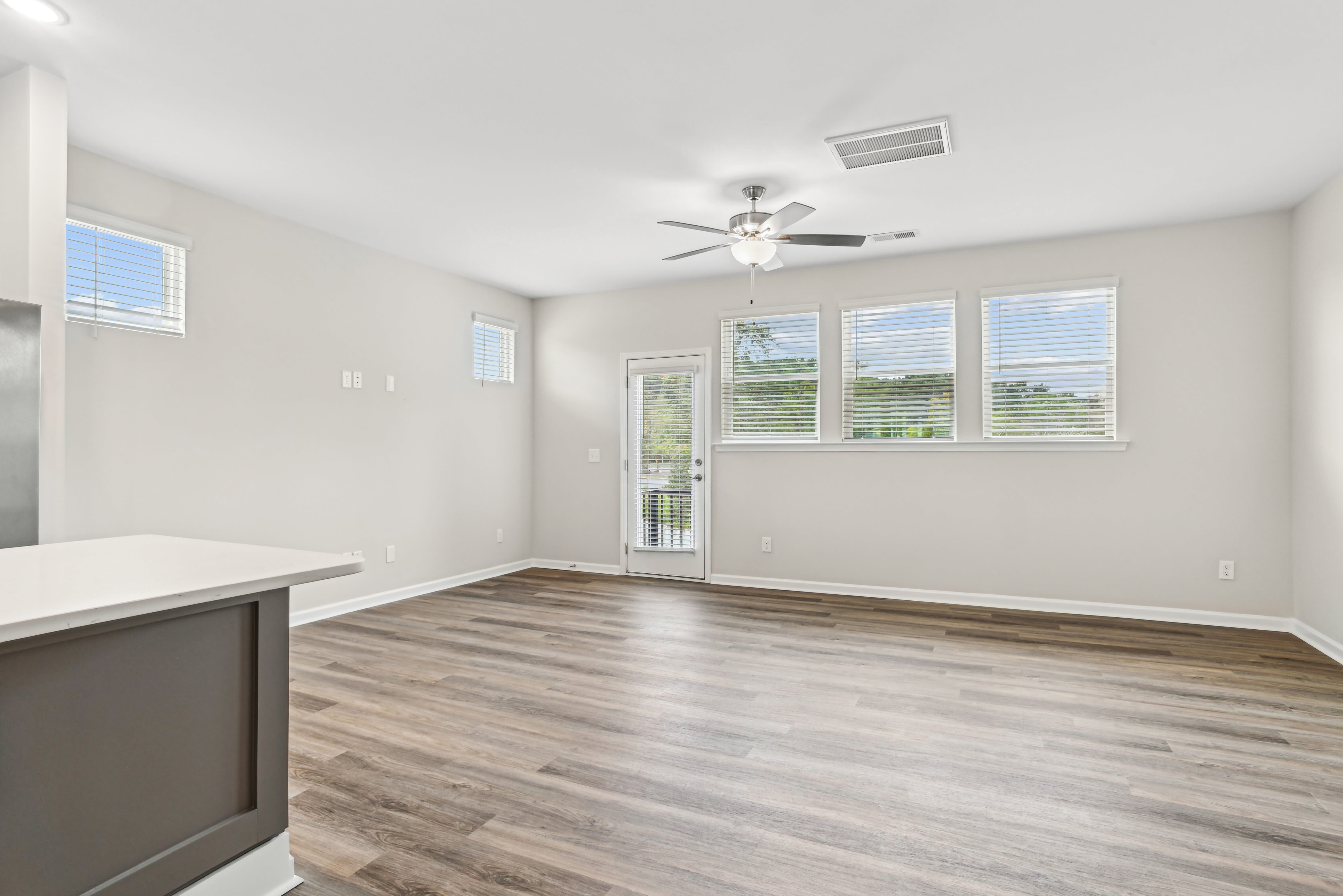 Living room with ceiling fan and window at Westmont Village in Charlotte, North Carolina