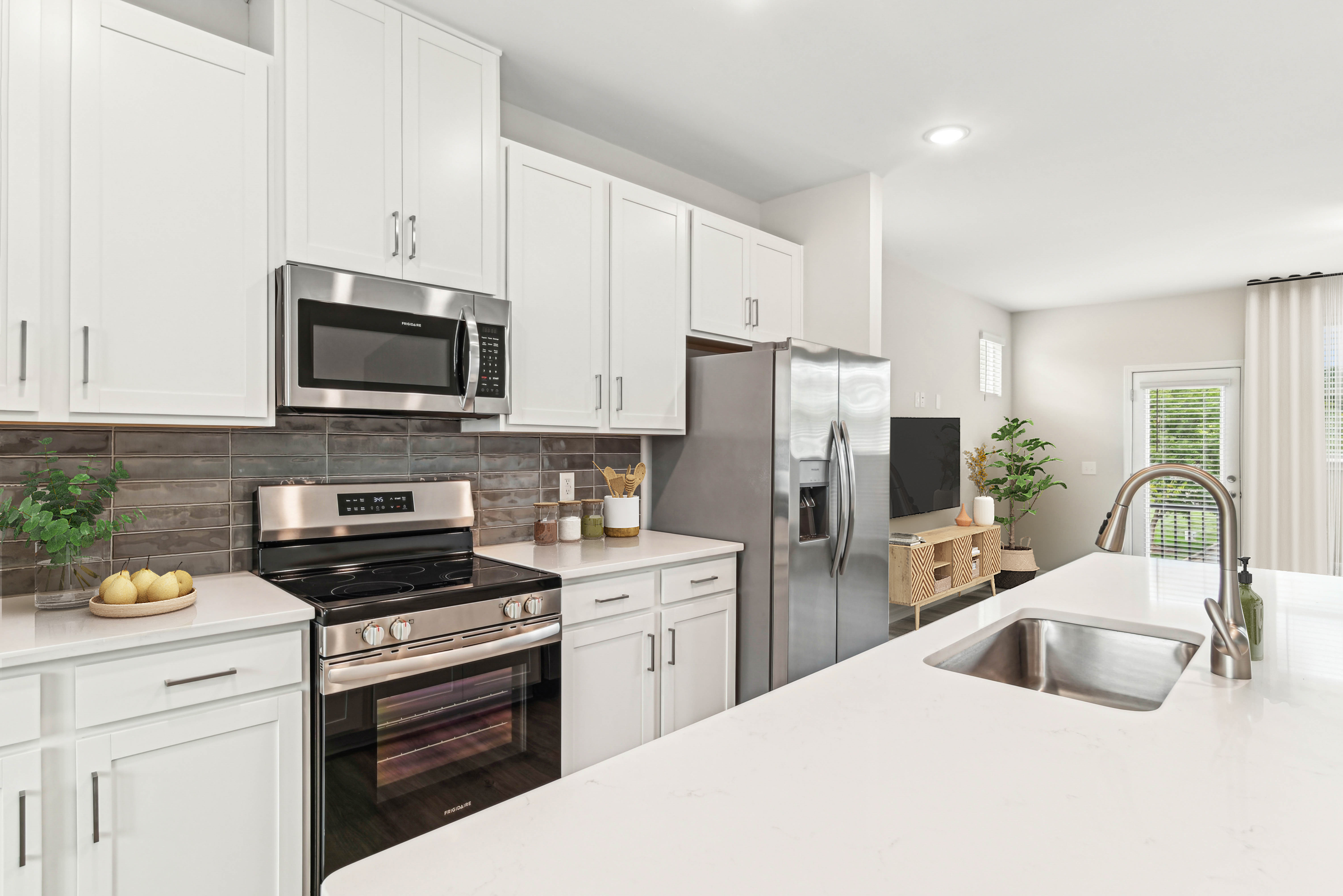 Fully equipped kitchen with granite countertops stainless steel appliances like a refrigerator, stove, and drawer microwave at Westmont Village in Charlotte, North Carolinatho