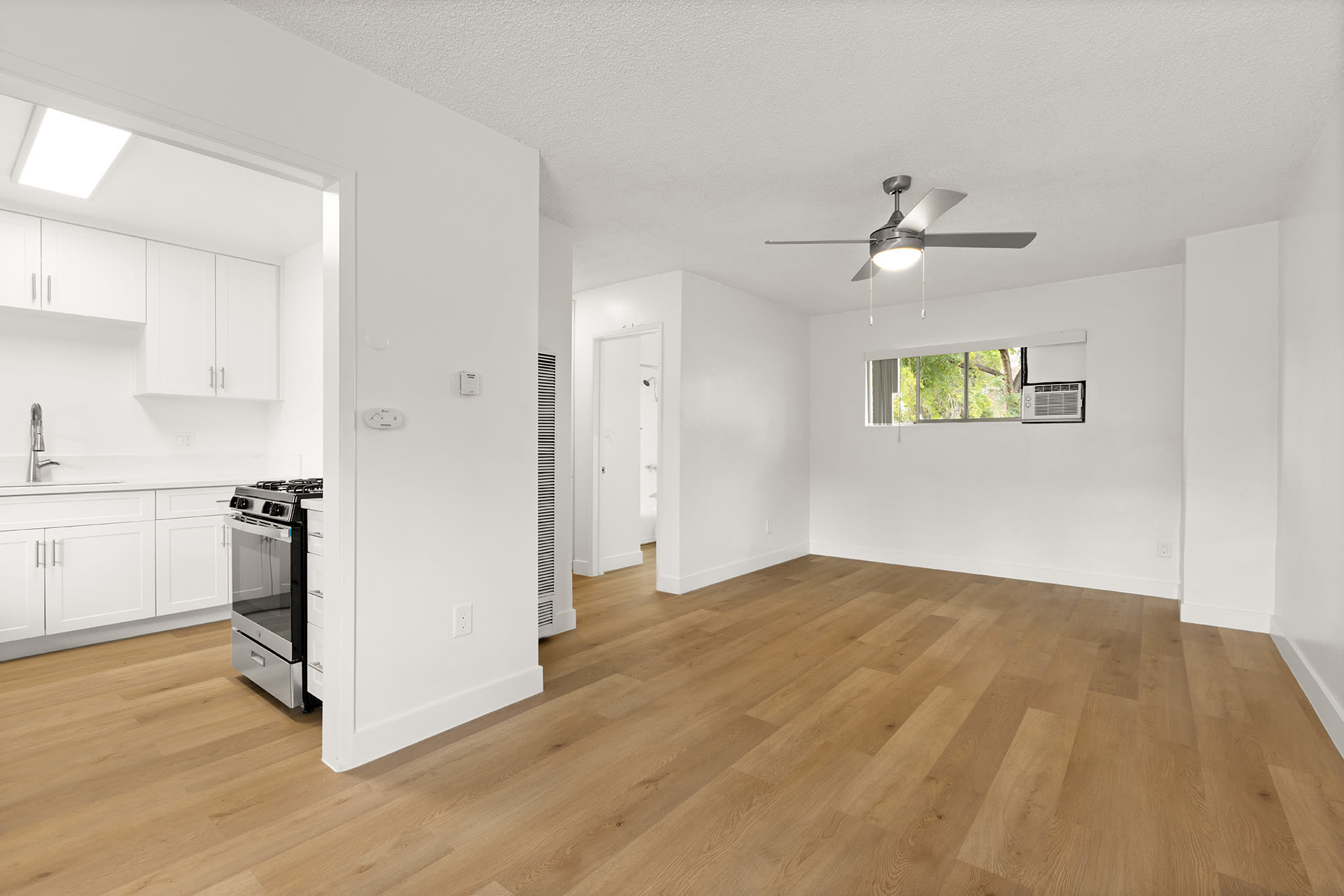 A spacious empty room with white walls and polished wooden floors at Terre at S Anza in El Cajon, California