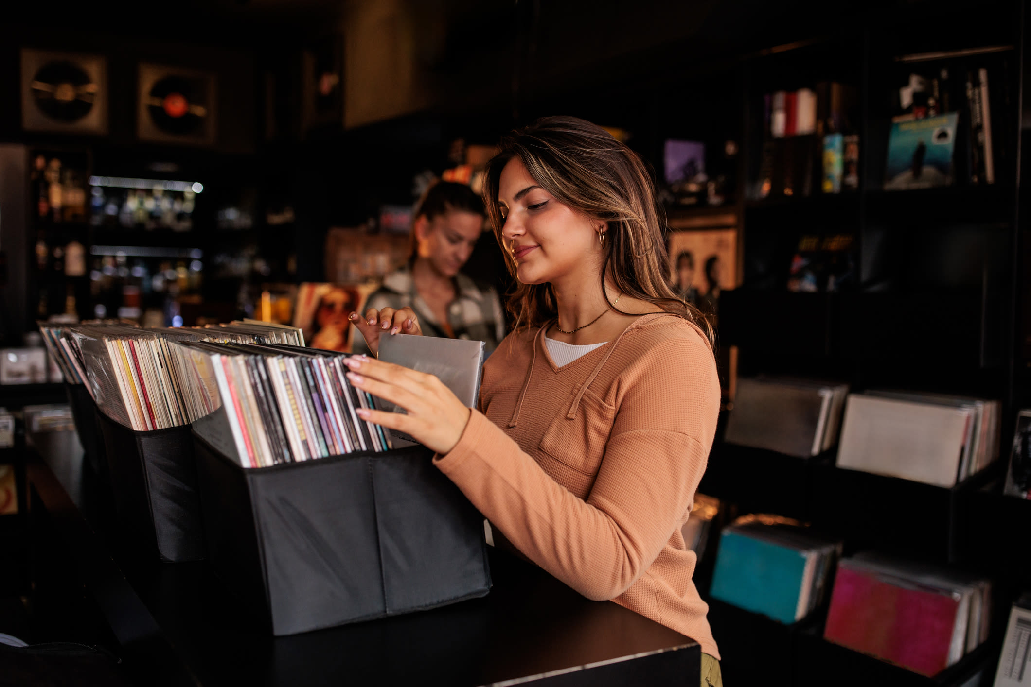 Woman searching records in a music store at Detroit Living in Detroit,