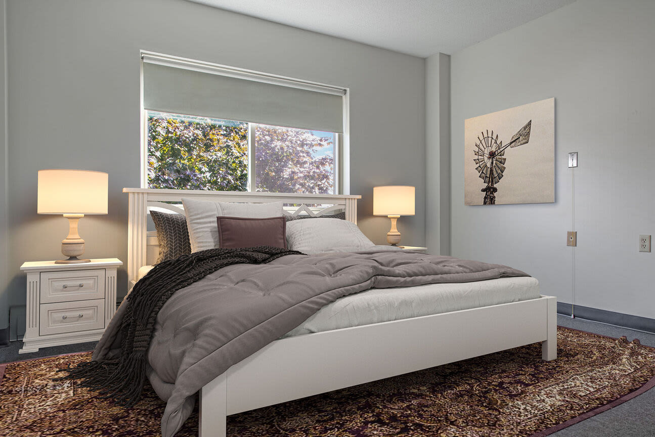 Well-lit apartment bedroom with king-size bed at Bedford Towers in New Bedford, Massachusetts