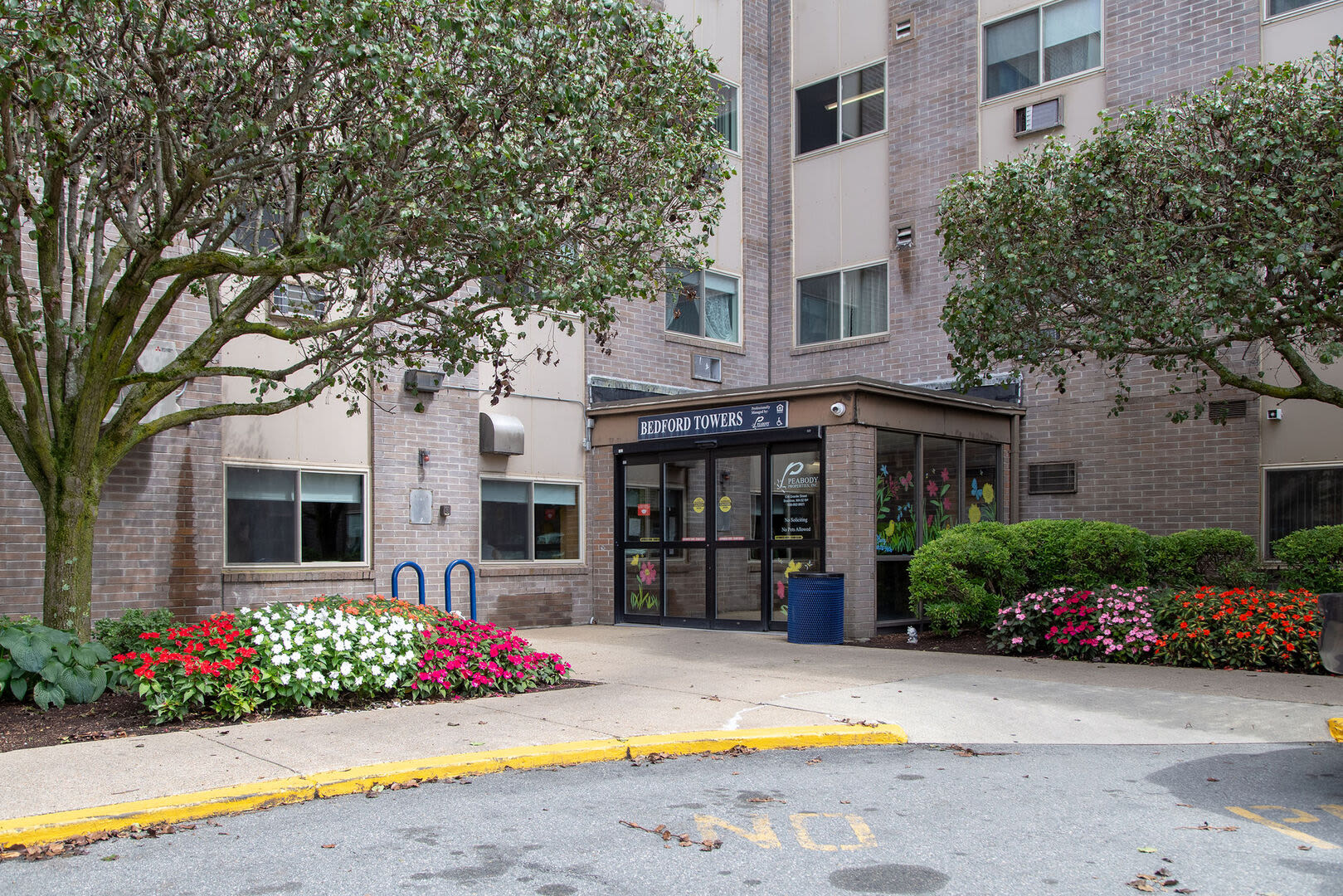 Entrance of the apartments with a beautiful pathway of flowers at Bedford Towers in New Bedford, Massachusetts