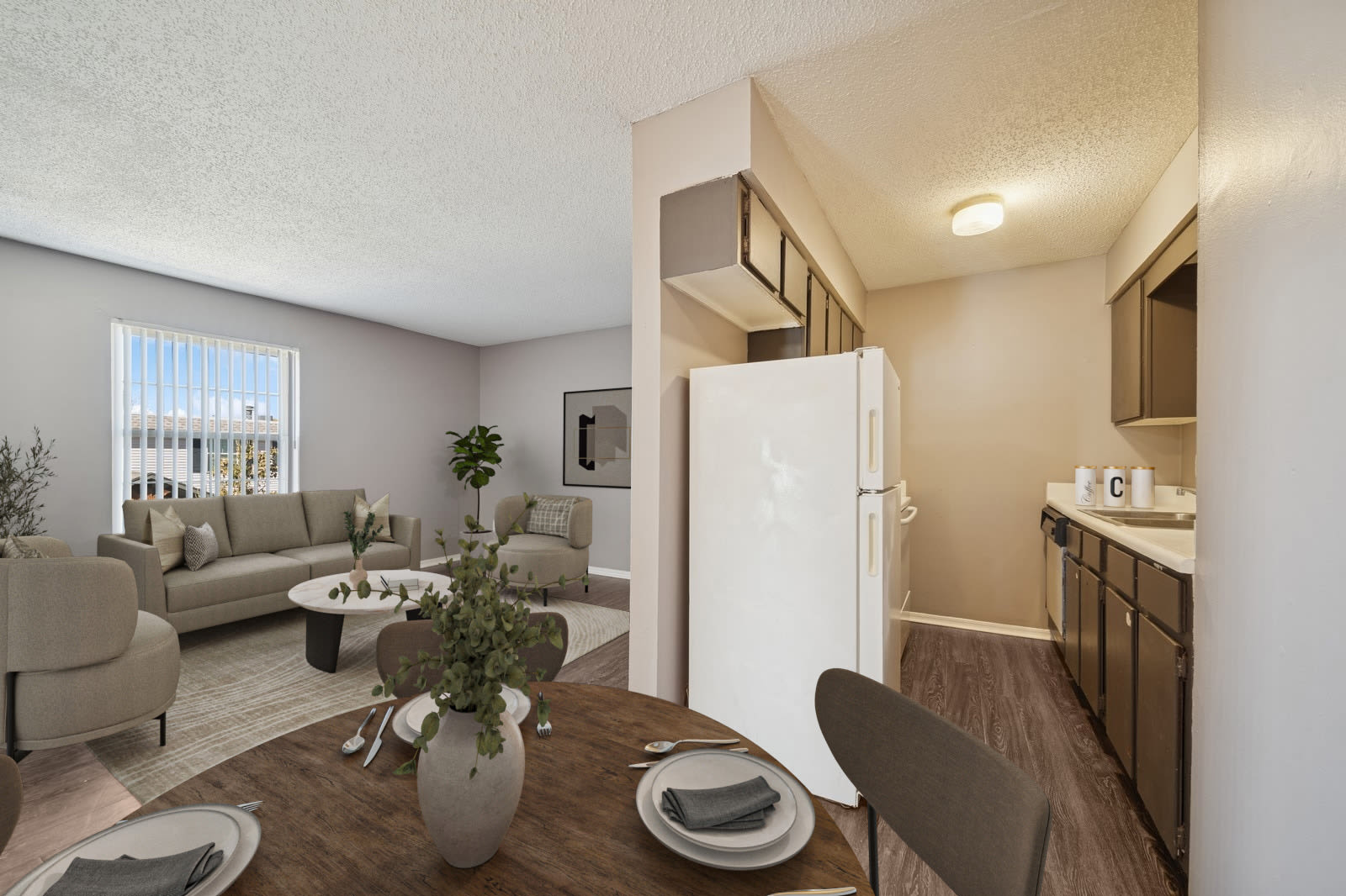 A spacious empty kitchen featuring hardwood floors and a refrigerator at Reeds Landing Apartments in Edmond, Oklahoma