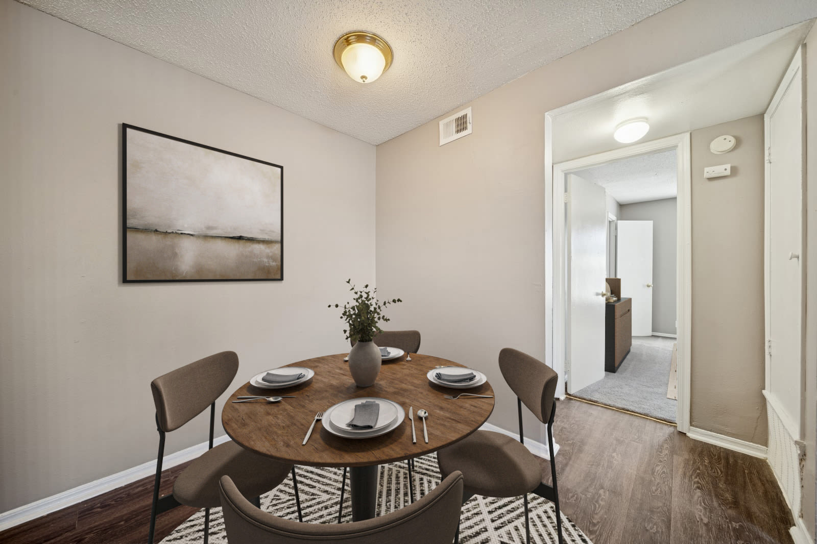 An apartment room with polished hardwood floors and a plain white door at Reeds Landing Apartments in Edmond, Oklahoma