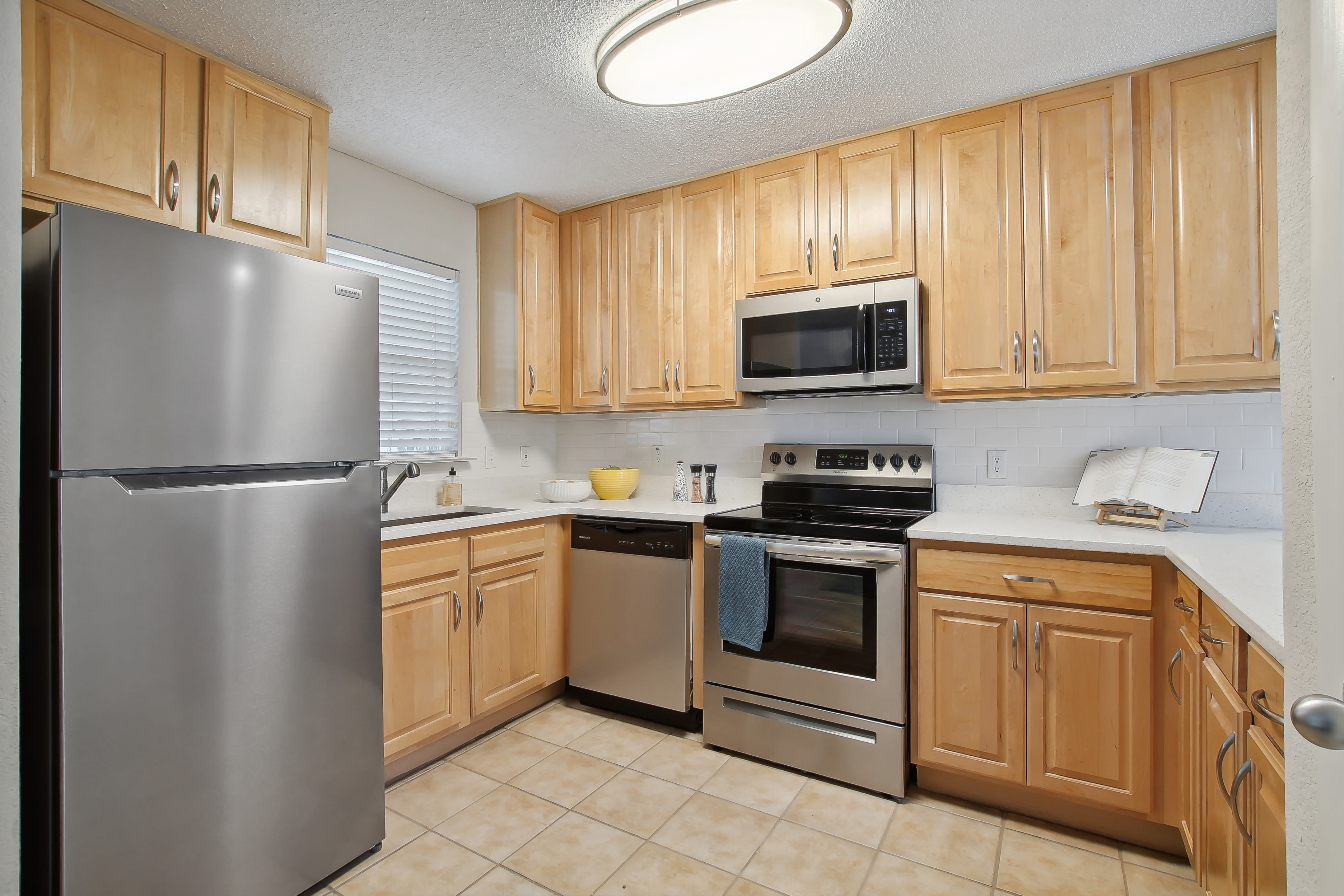 Kitchen with fridge and cabinets at The Canopy Apartment Villas in Orlando, Florida