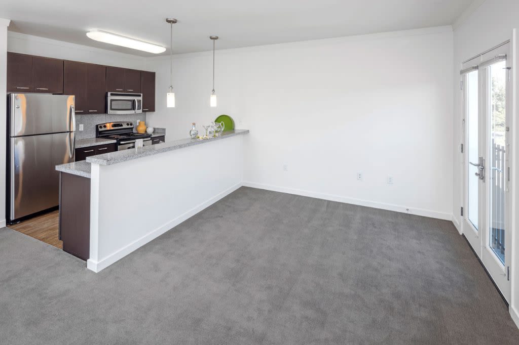 Open kitchen with plush carpet at Bell Tower at Old Town Square in Wilsonville, Oregon