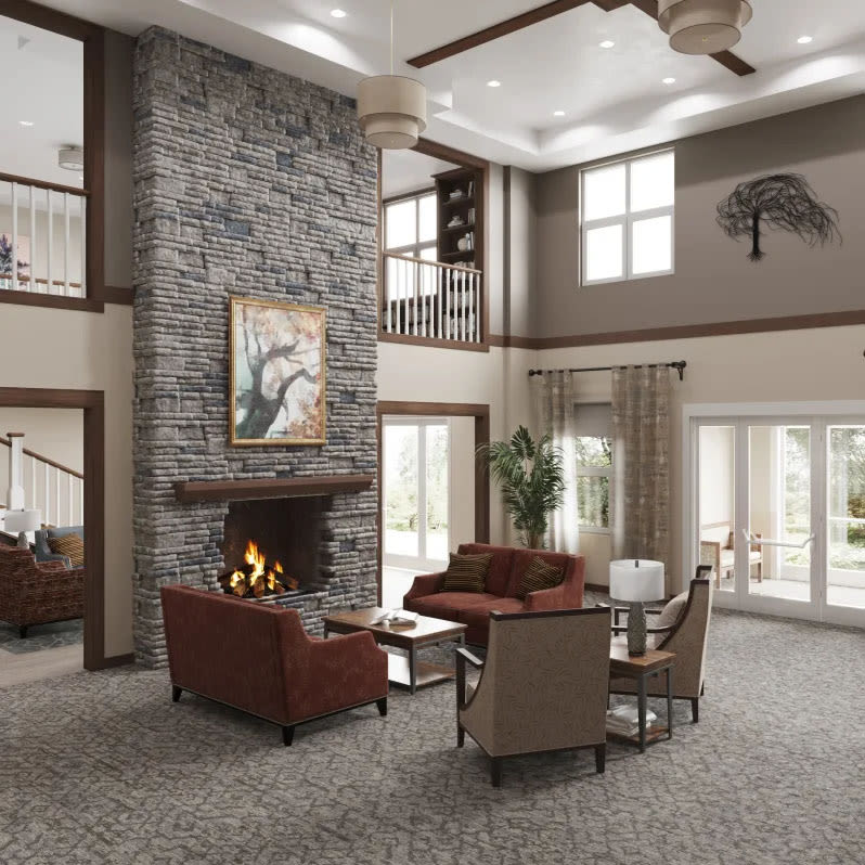 Resident sitting on a couch reading a newspaper in a large fireplace lounge