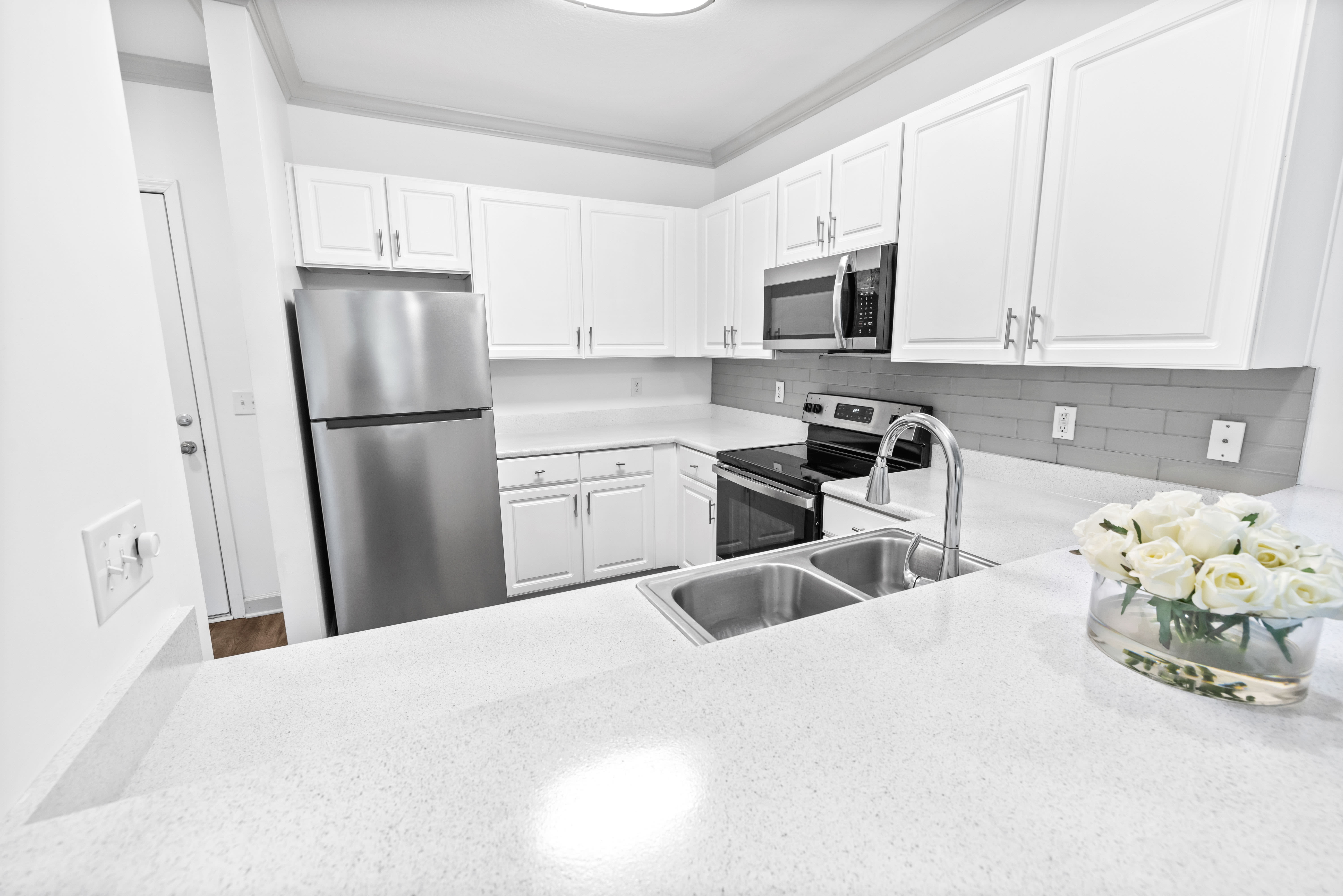 Model apartment's spacious kitchen with ample cupboard space for storage at Olympus Carrington in Pooler, Georgia