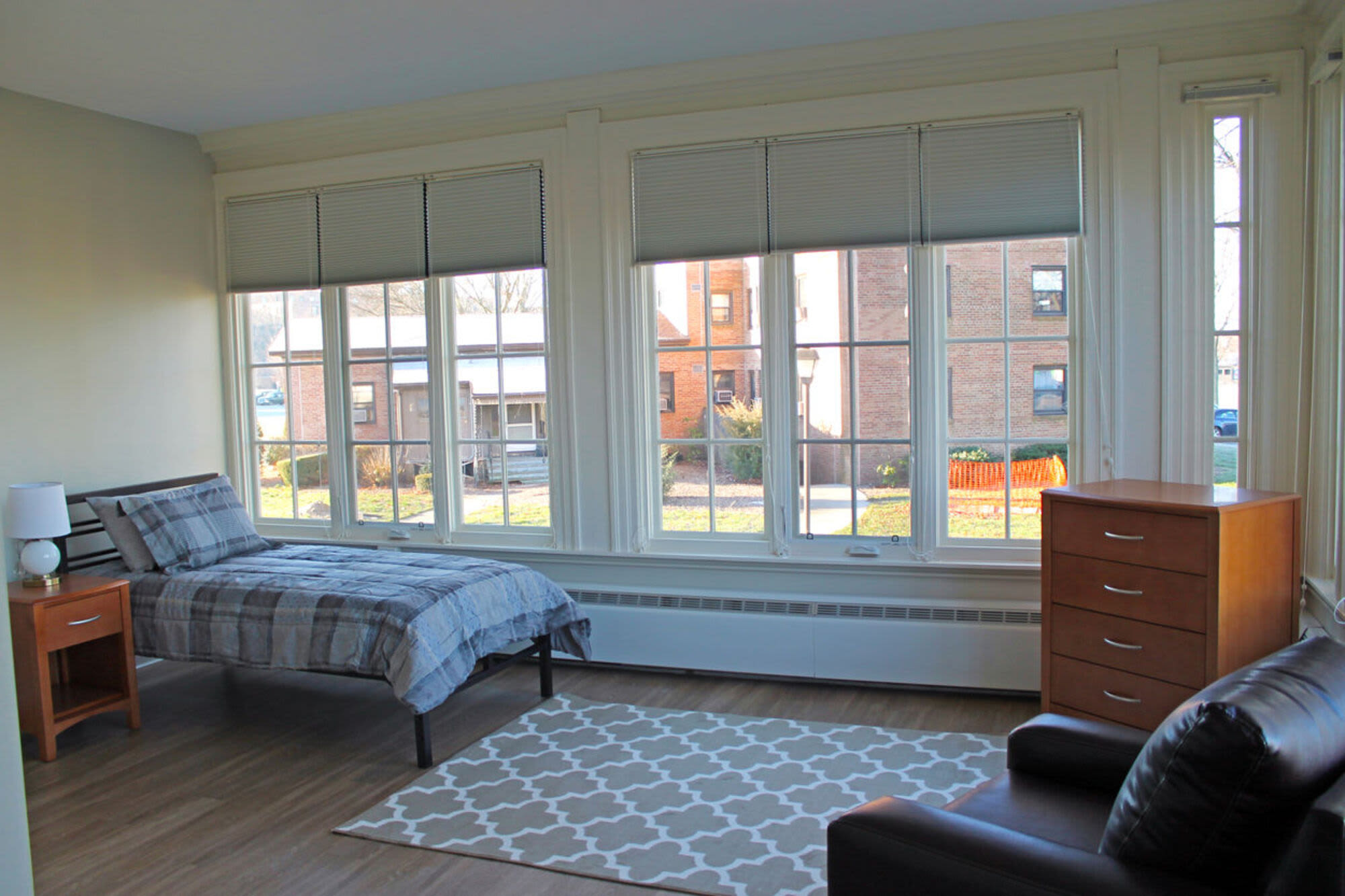 Bedroom with a bed and large windows for ventilation at Howard House in Brockton, Massachusetts, 