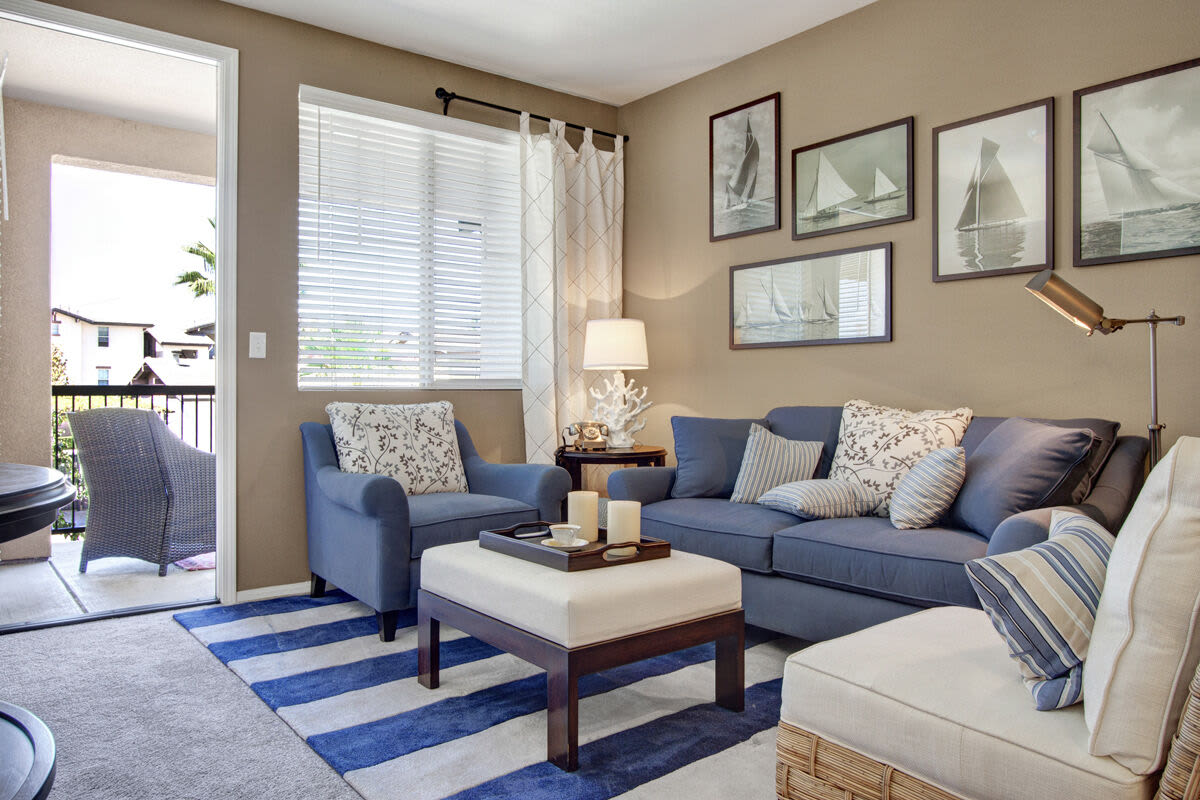 Spacious living room with couch, coffee table and access to patio through door with glass window at Rivers Edge in Lake Elsinore, California