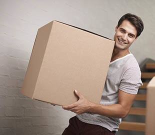 A man holding a box near Best Storage