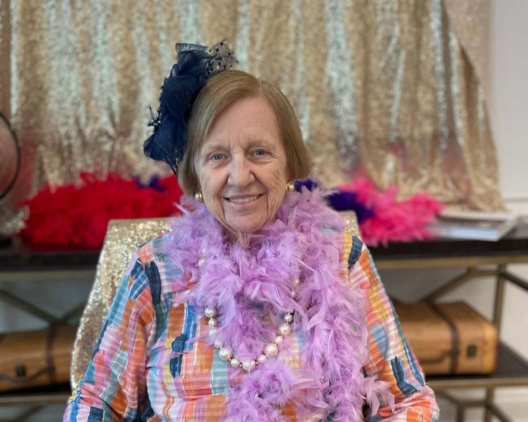 Gleeful resident with a glass of wine and a gingerbread house at The Blake at Miramar Beach in Miramar Beach, Florida