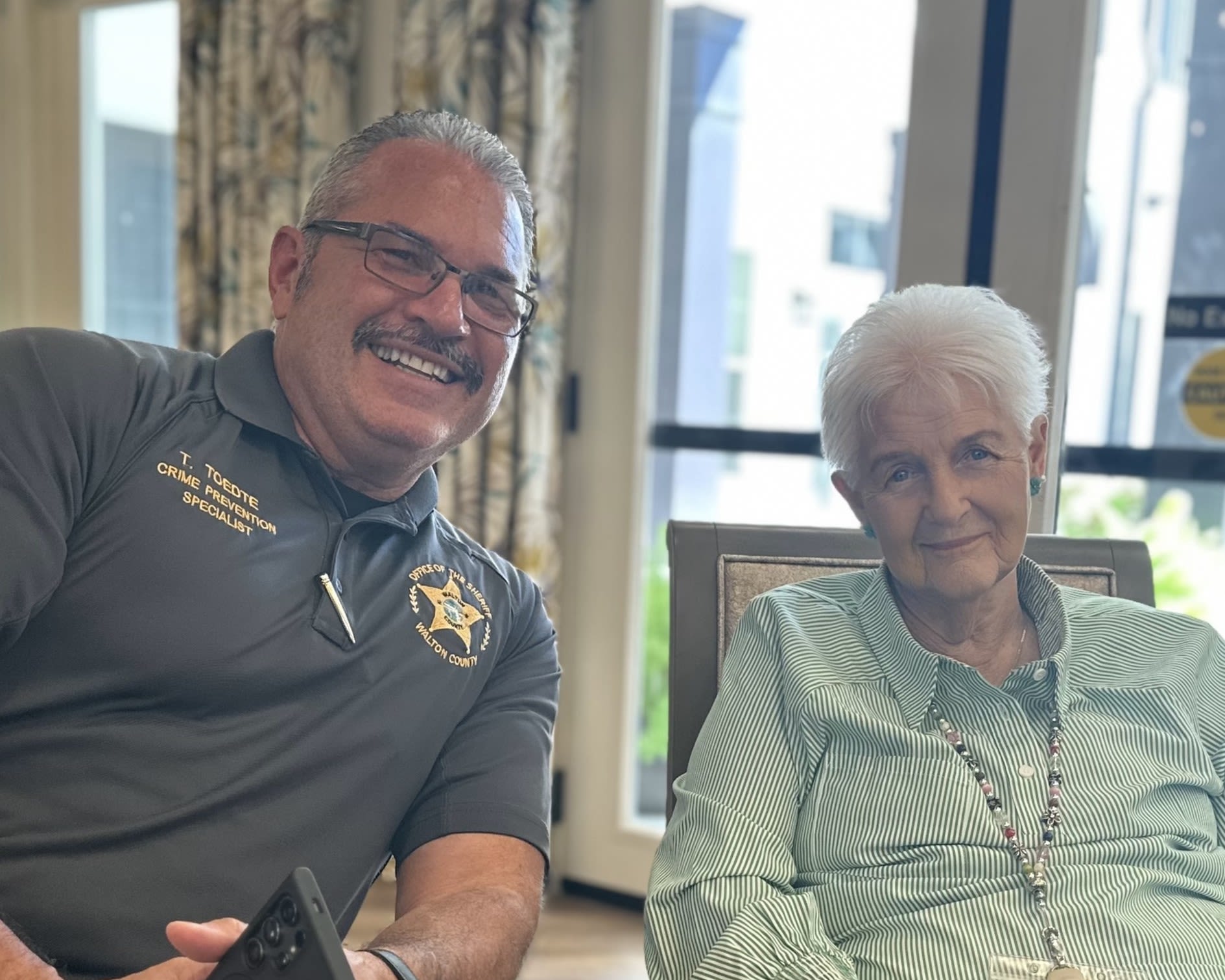 Caretakers posing with props for a photo with a resident at The Blake at Miramar Beach in Miramar Beach, Florida