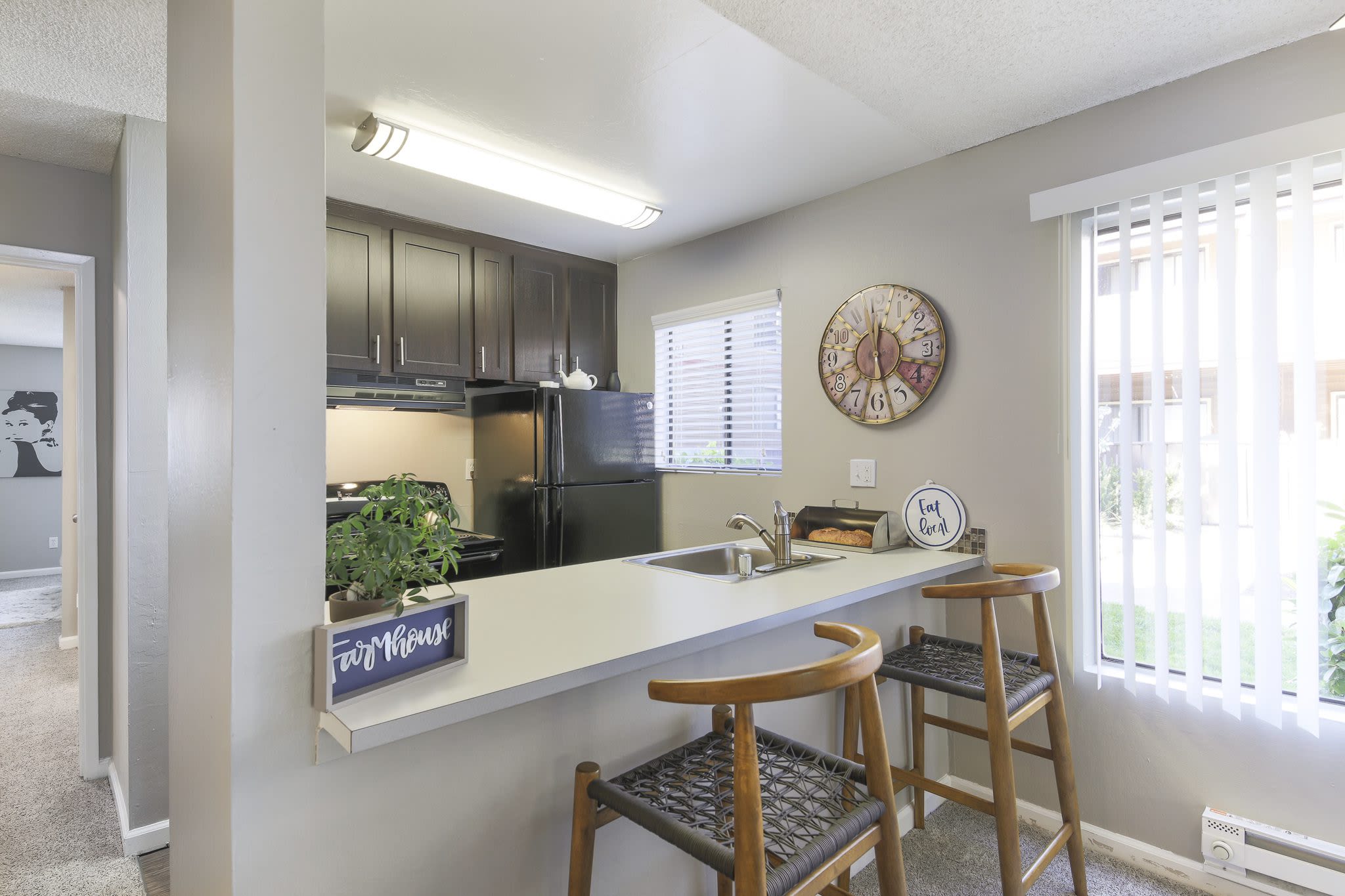 Modern kitchen with barstools at Woodchase Apartments in San Leandro, California