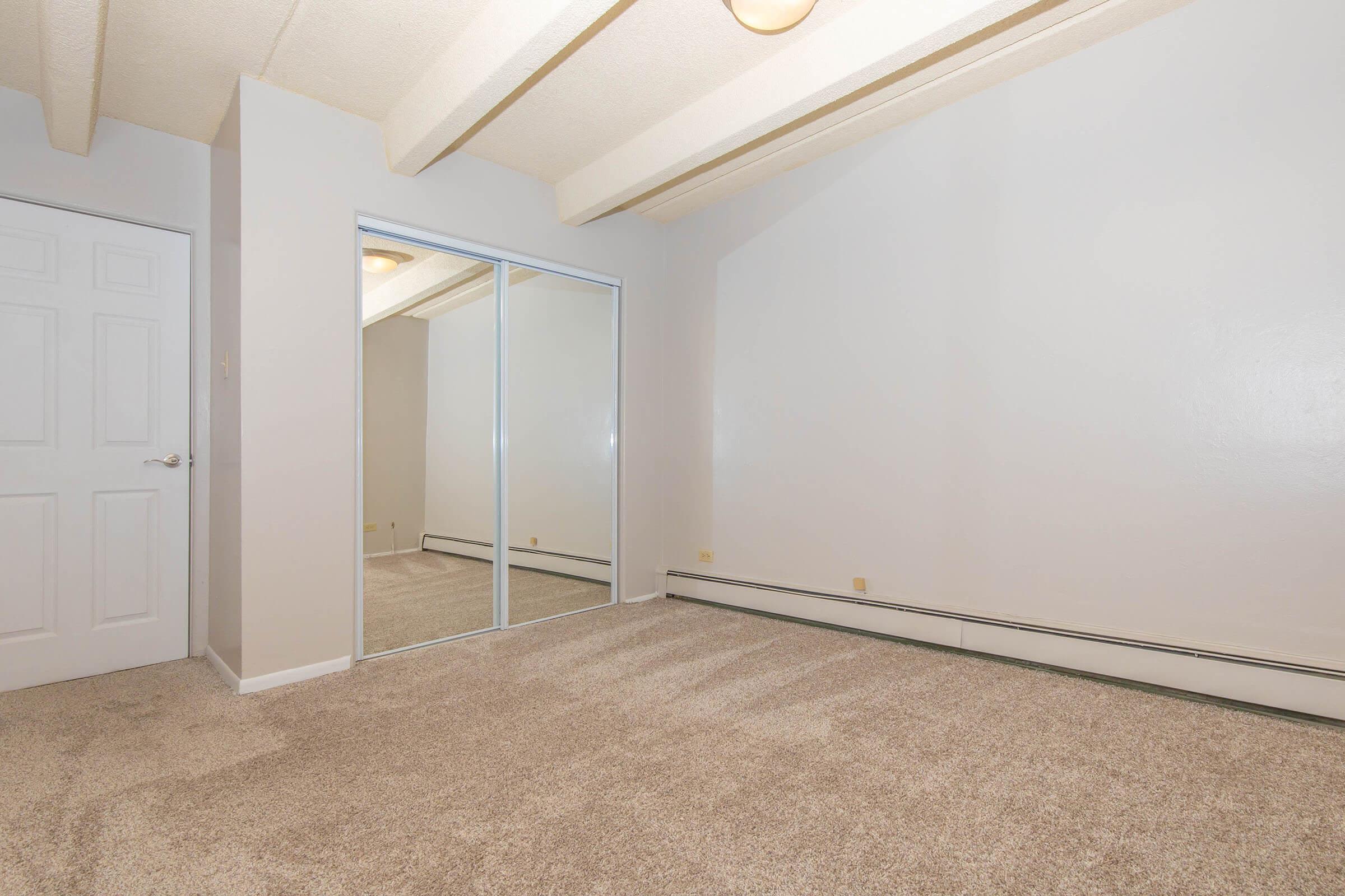 Bedroom with mirrored closet doors at Boulder Crescent in Colorado Springs, Colorado