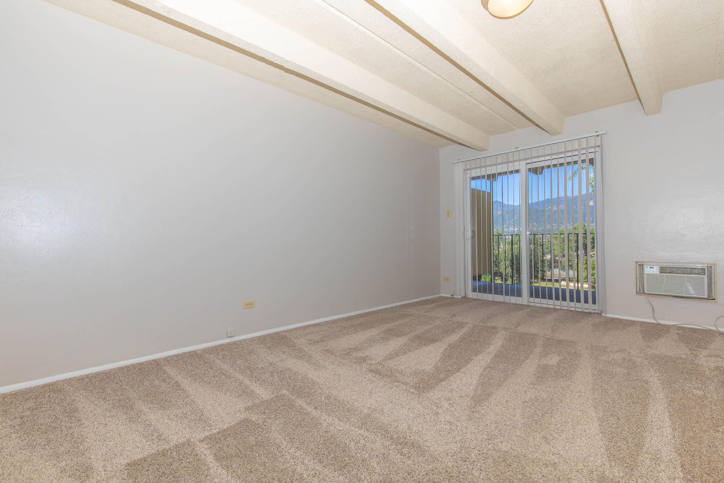 Bedroom with beamed ceiling and slider door at Boulder Crescent in Colorado Springs, Colorado