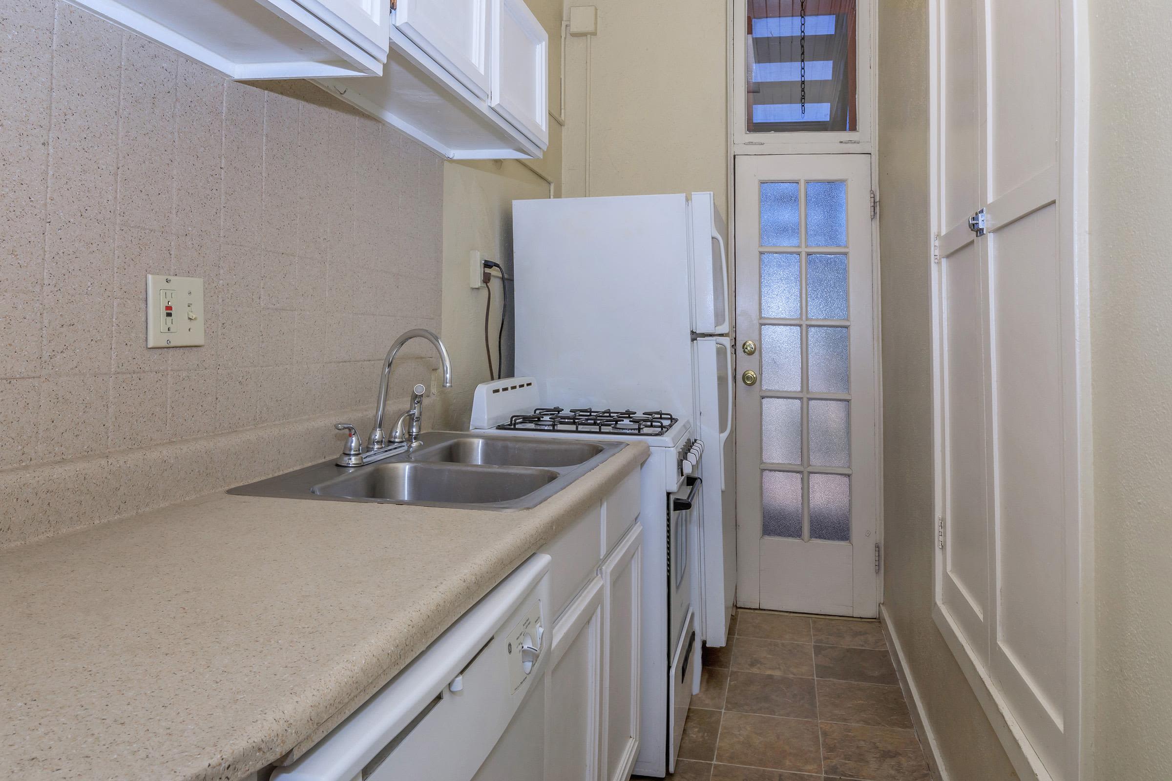 Kitchen with white appliances and door at Cascade Park in Colorado Springs,Colorado