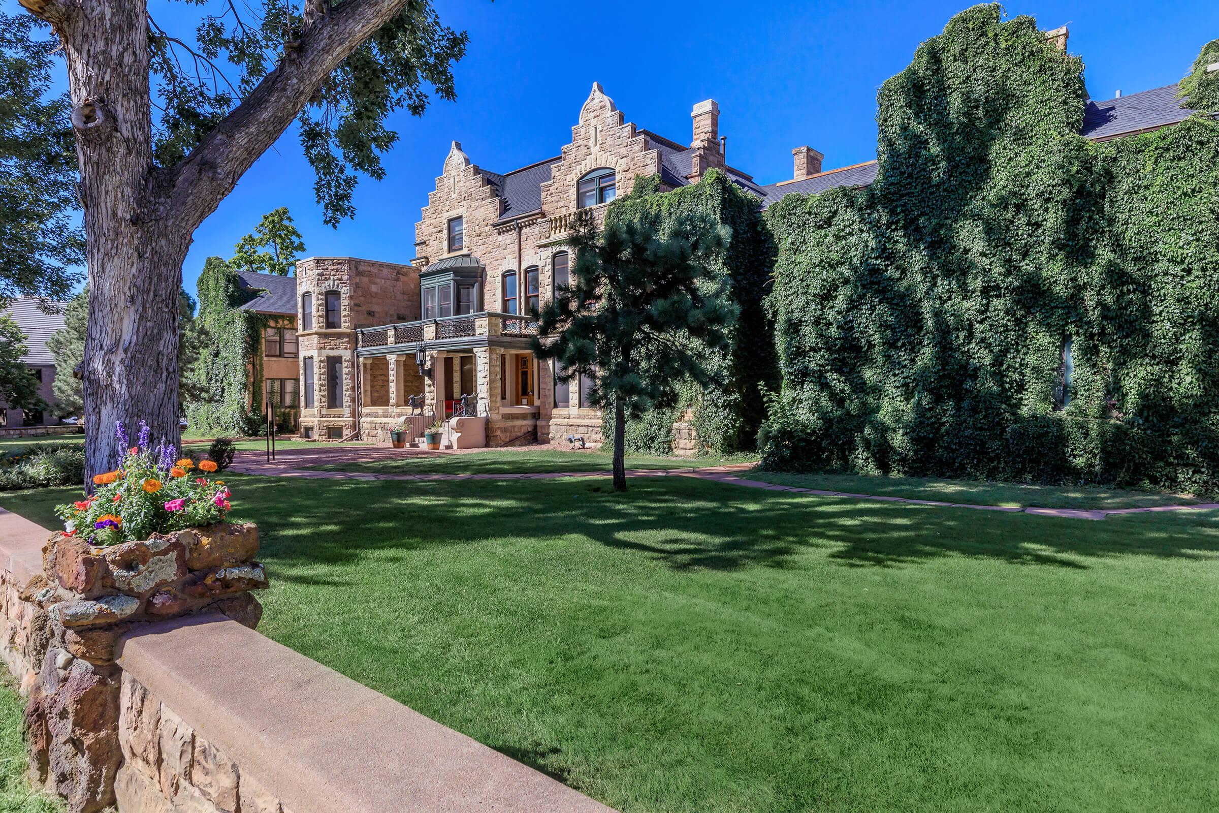 Exterior view of grassy area next to stone building at Cascade Park in Colorado Springs, Colorado