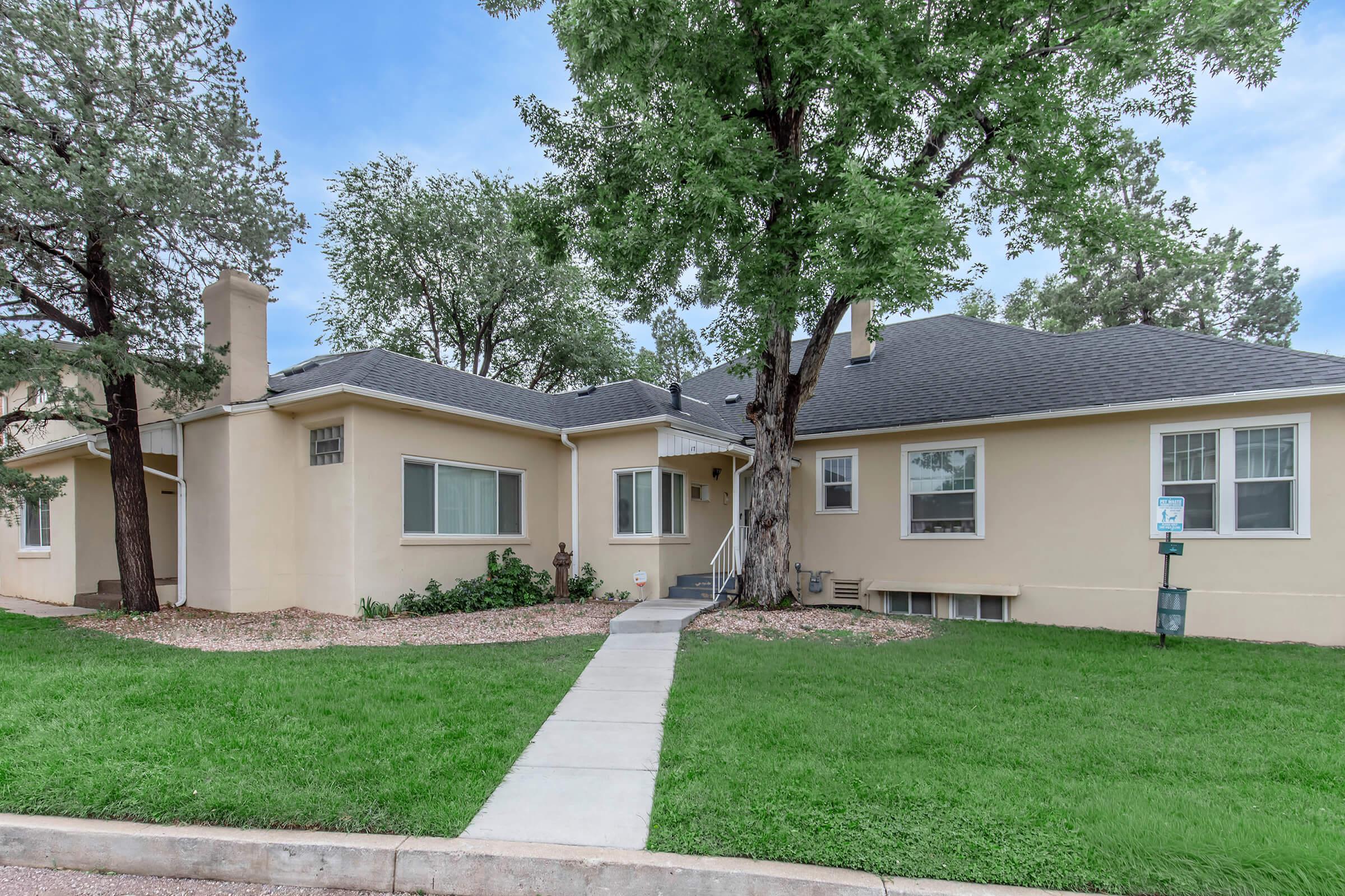 Exterior view of pathway to cream colored apartments at Cascade Park in Colorado Springs, Colorado