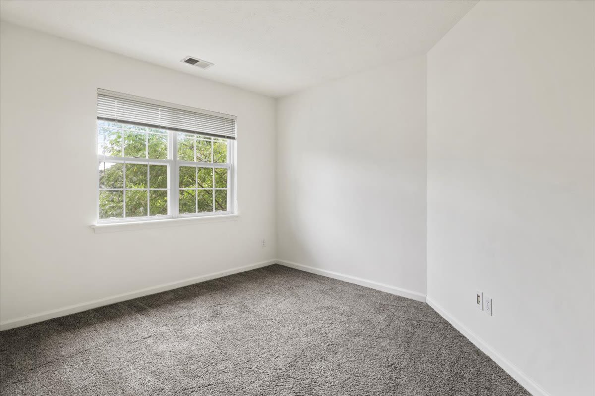 Bedroom with a window at Summit Knolls Apartments & Townhomes in Webster, New York