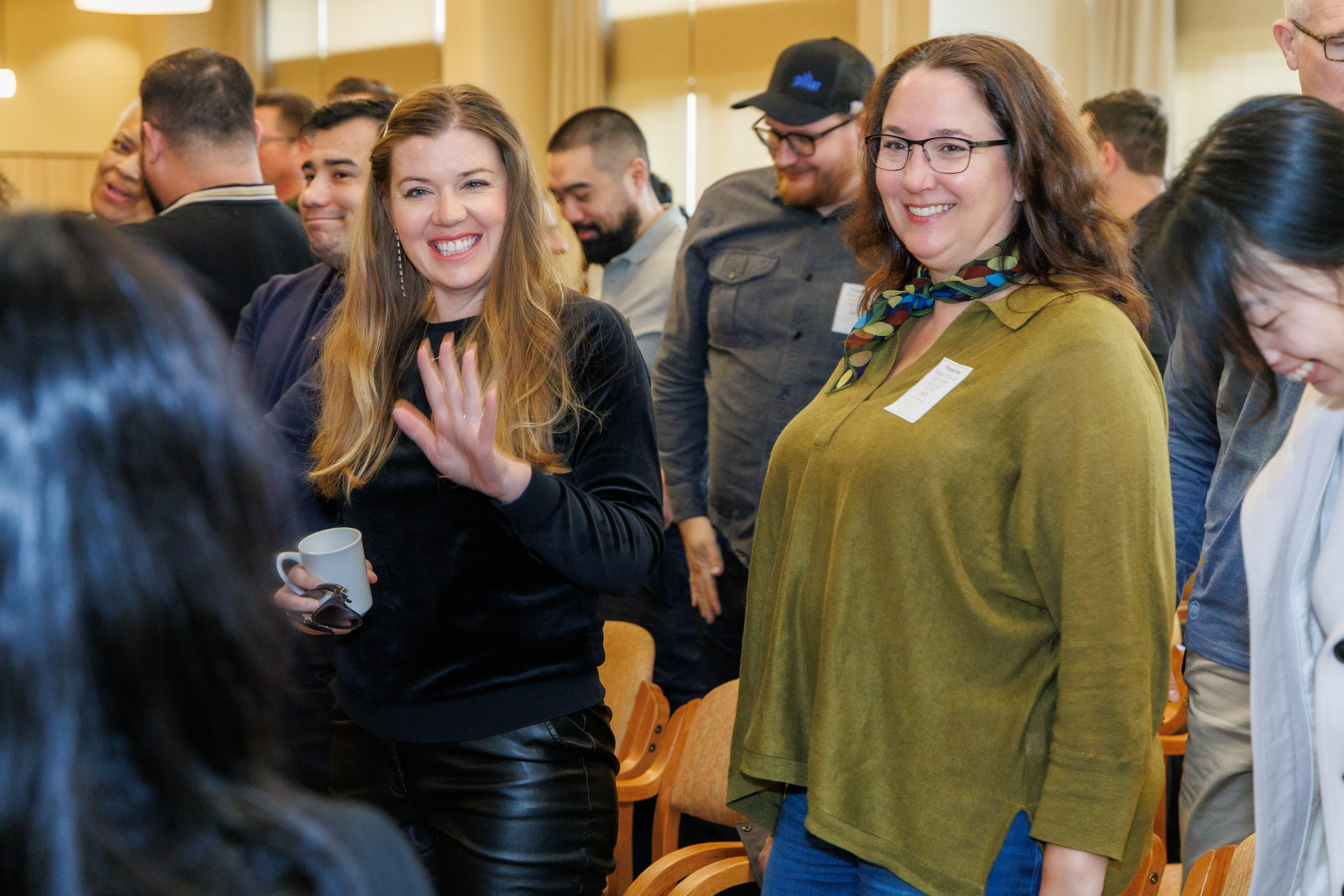 People gathered in a room during an event, chatting while standing among other attendees at Pillar Properties in Seattle, Washington