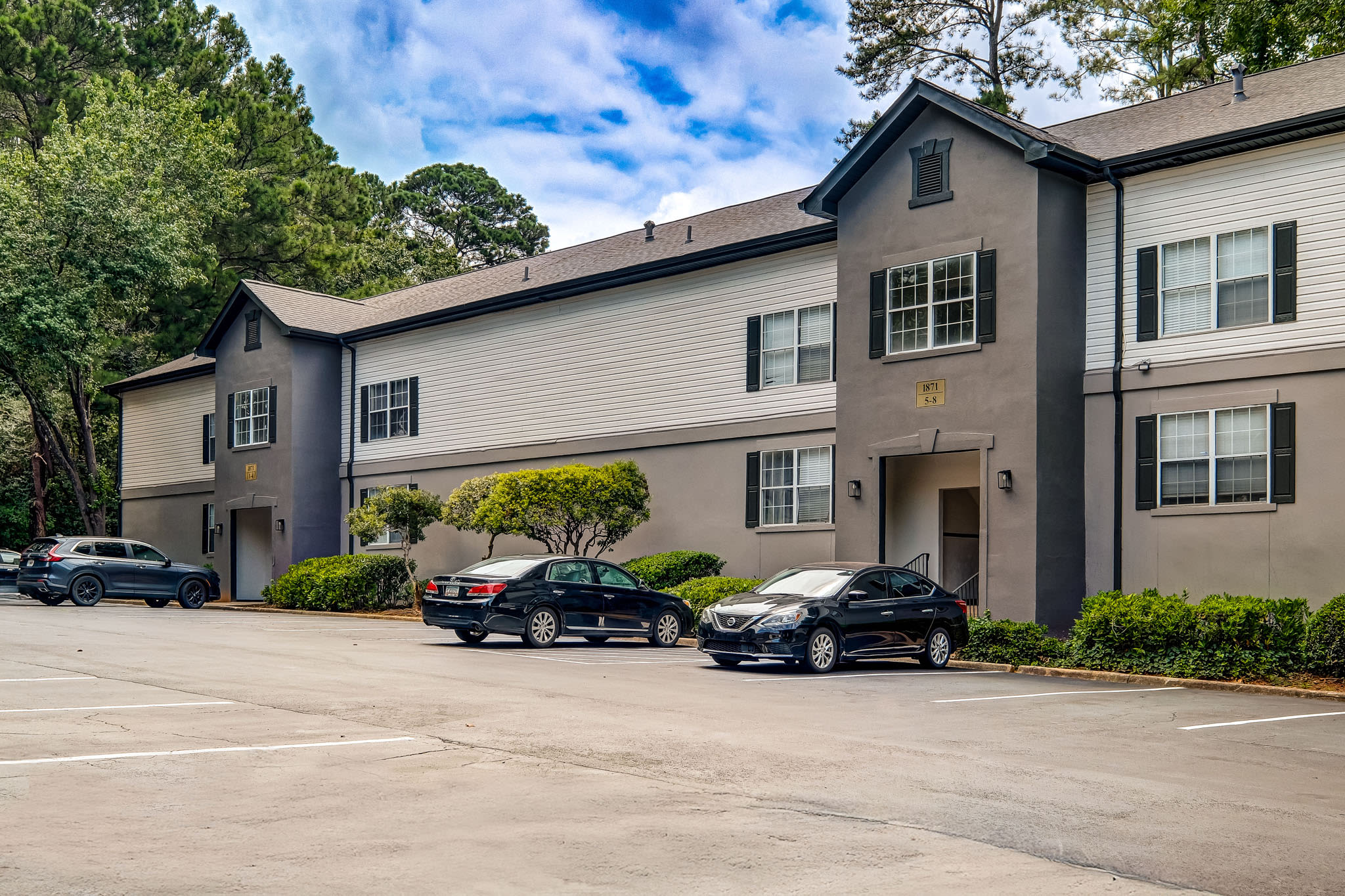 Apartment building parking lot with lined spaces, vehicles, and two‑story residential buildings at LaVista Crossing in Tucker, Georgia
