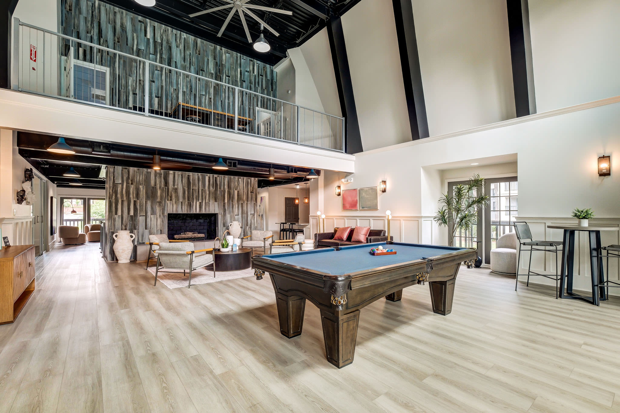 Community clubhouse interior with pool table, high ceilings, lounge seating, and modern design at LaVista Crossing in Tucker, Georgia