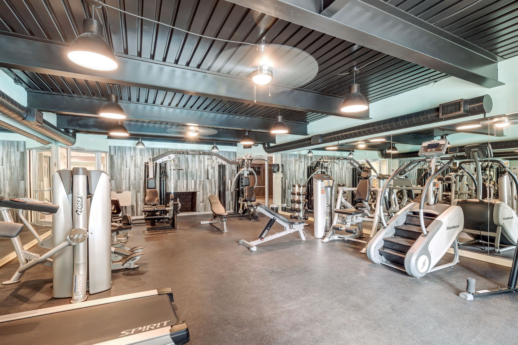 Fitness center with strength-training machines, treadmills, stair-stepper, and mirrored walls at LaVista Crossing in Tucker, Georgia