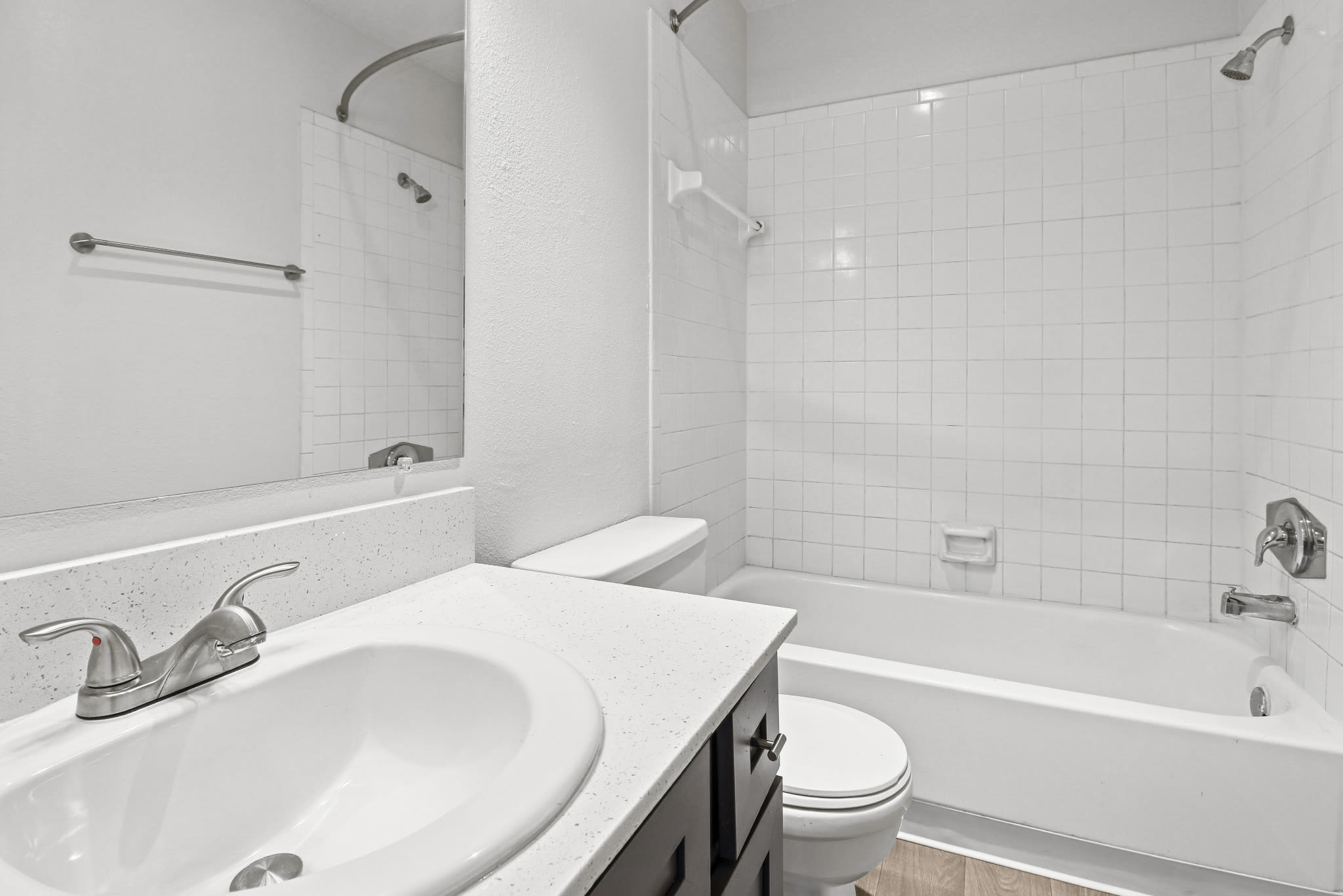 Bathroom with sink vanity and white tiled shower‑tub combo at Pinewood Estates in Albuquerque, New Mexico
