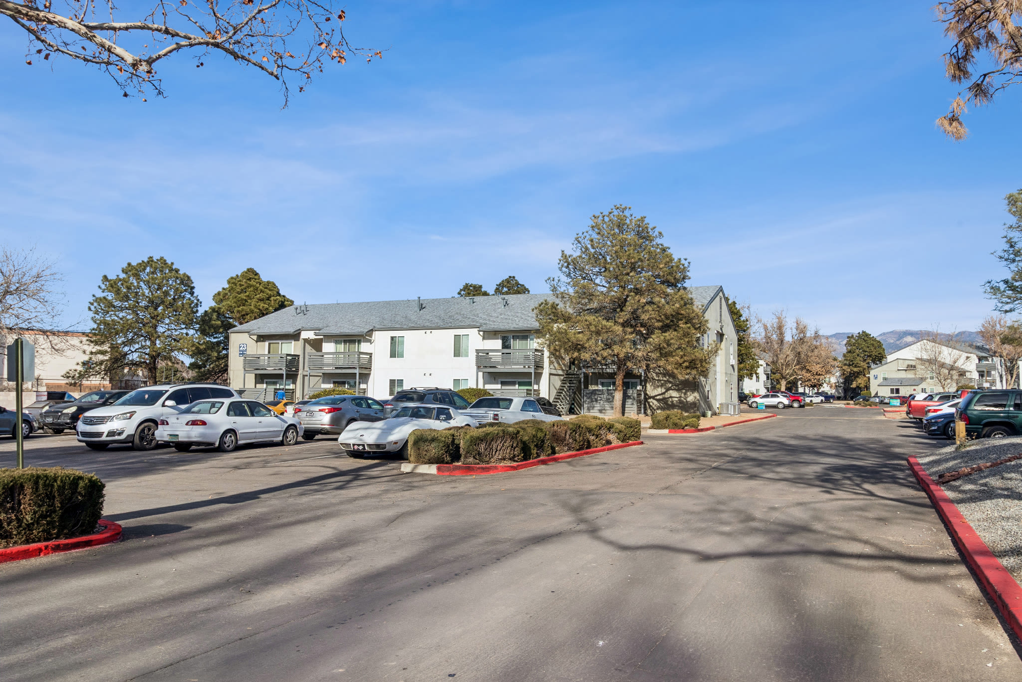 Parking lot in front of multi‑unit residential buildings at Pinewood Estates in Albuquerque, New Mexico
