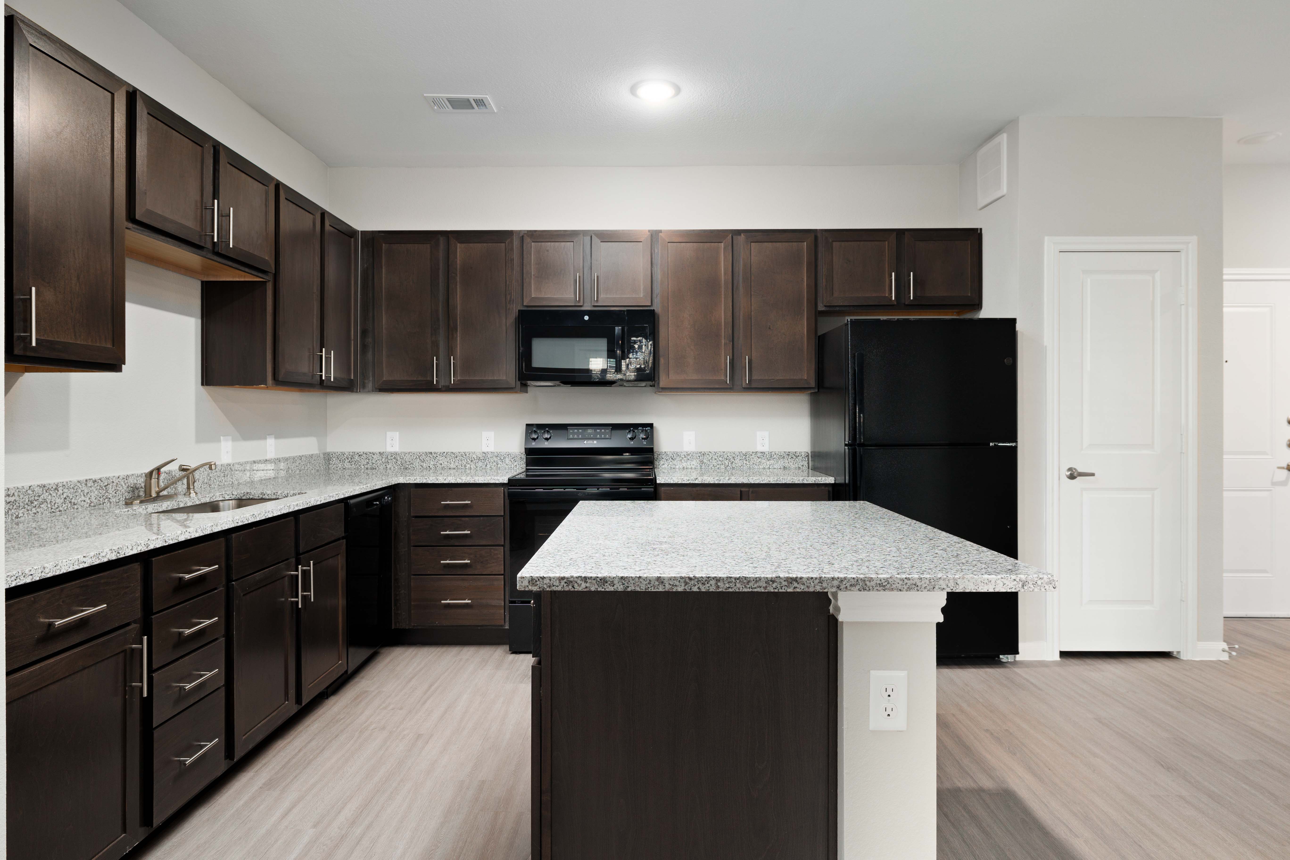 Open kitchen with spacious granite platform at Preserve at Gresham Lake in Raleigh, North Carolina