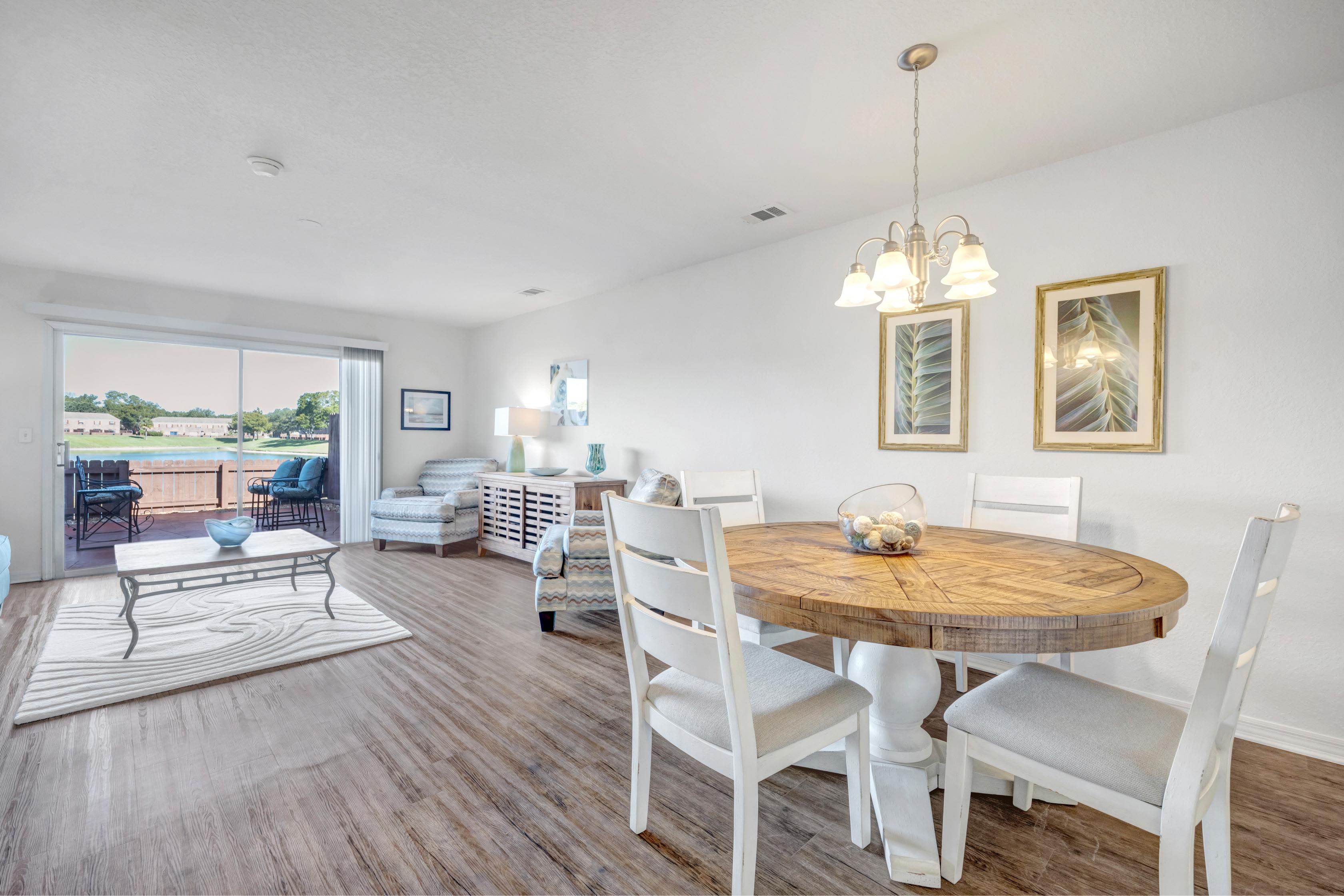 Spacious dining room with hanging lamps and attached living room at Carlton Arms Of Ocala in Ocala, Florida