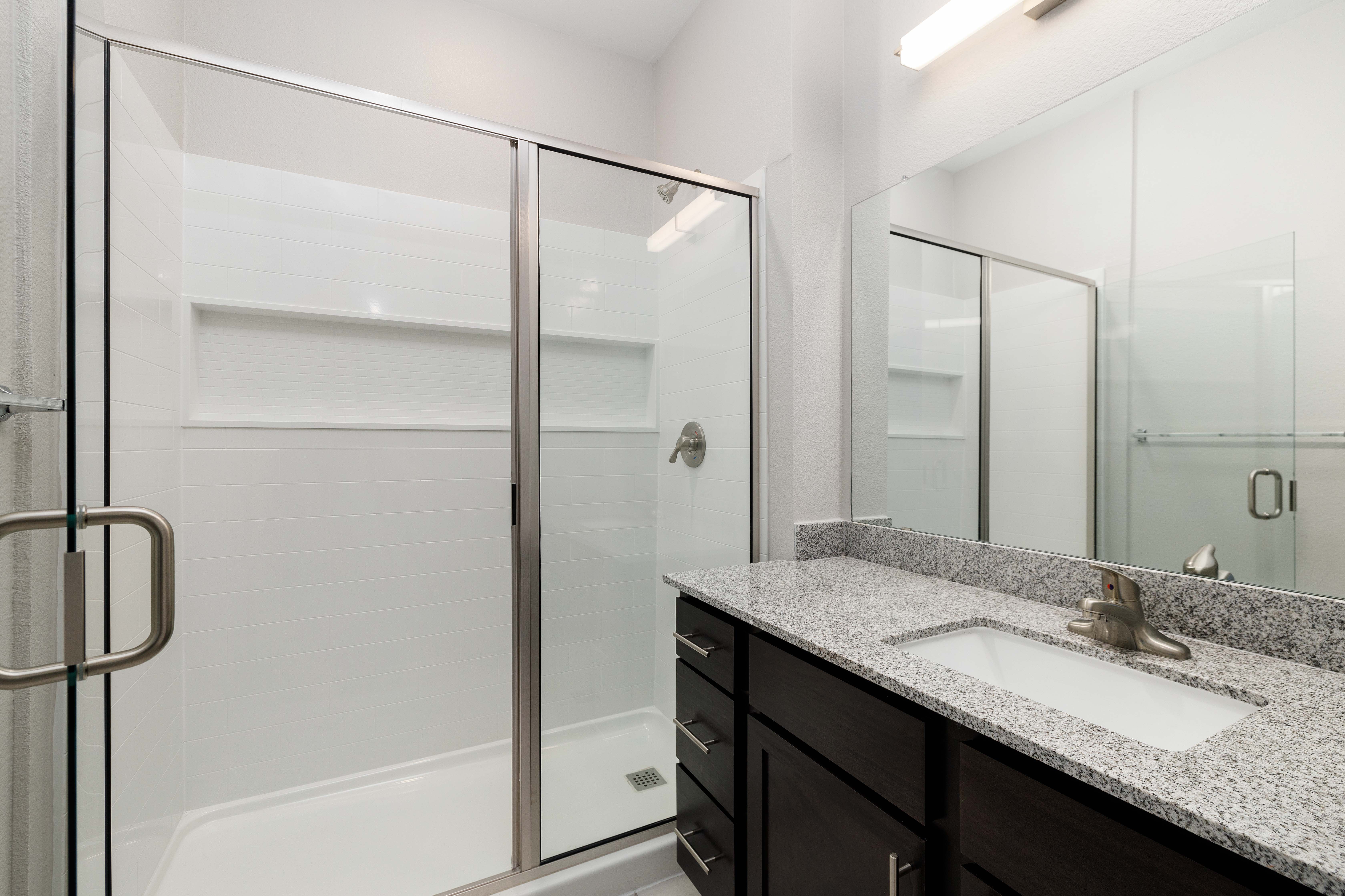 Bright bathroom with glass sliding doors at Legacy On Kiest in Dallas, Texas