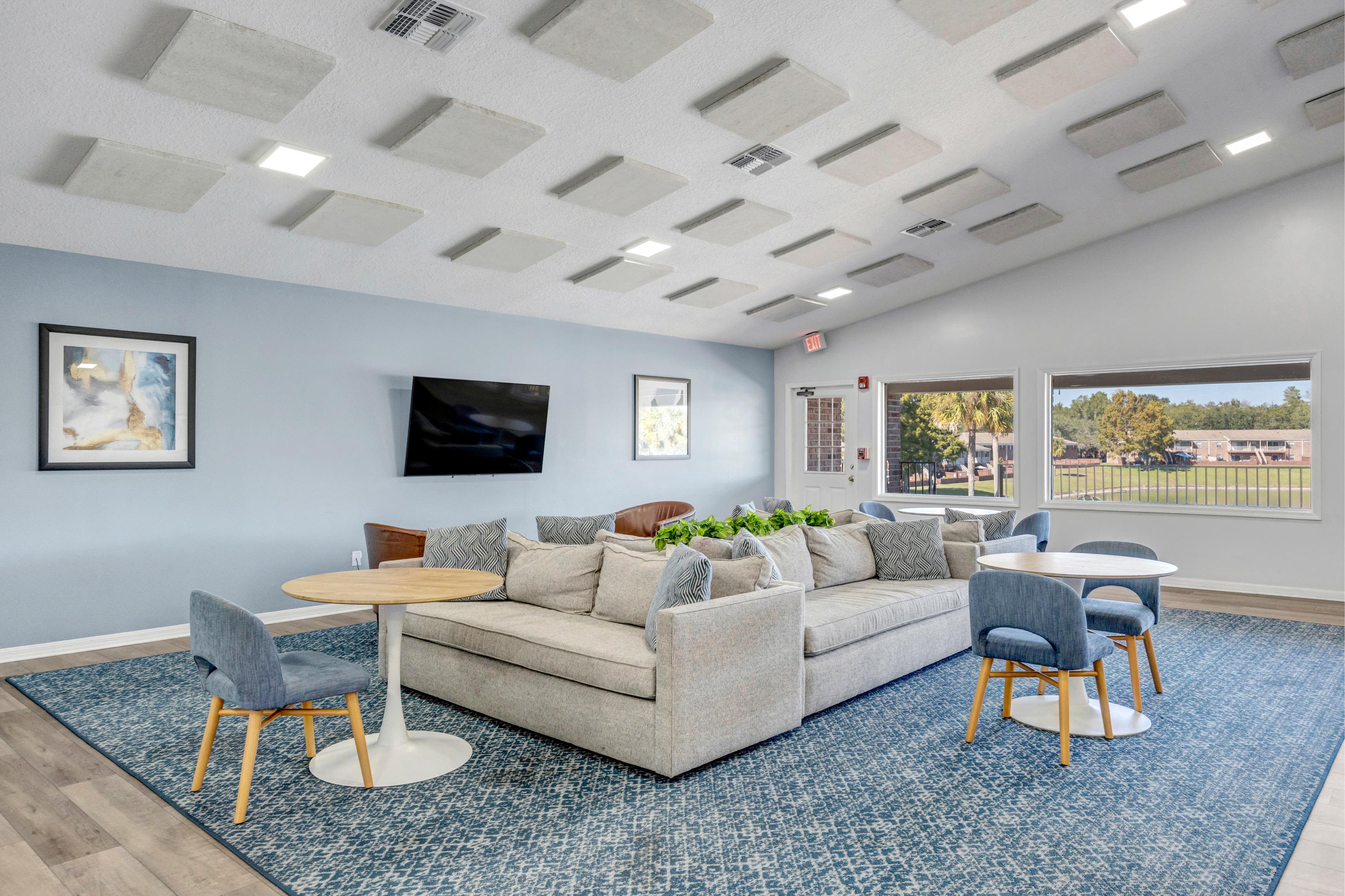 Community lounge area with wall mounted tv unit at Carlton Arms Of Ocala in Ocala, Florida
