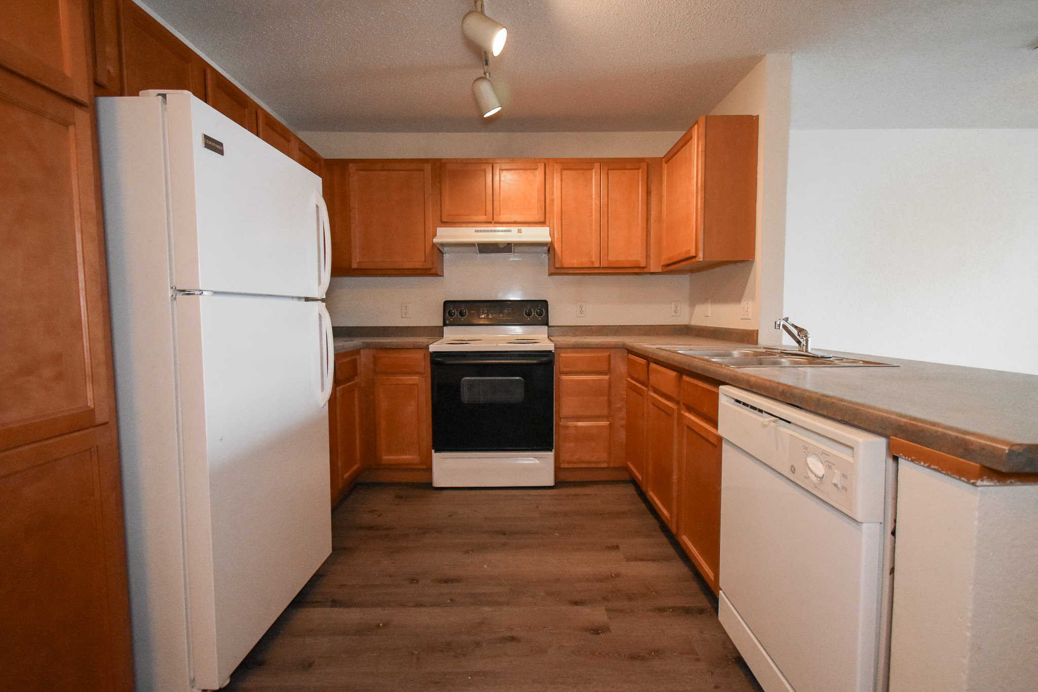 Modern kitchen with wood-style flooring and appliances at River Run Apartments in Minneapolis, Minnesota
