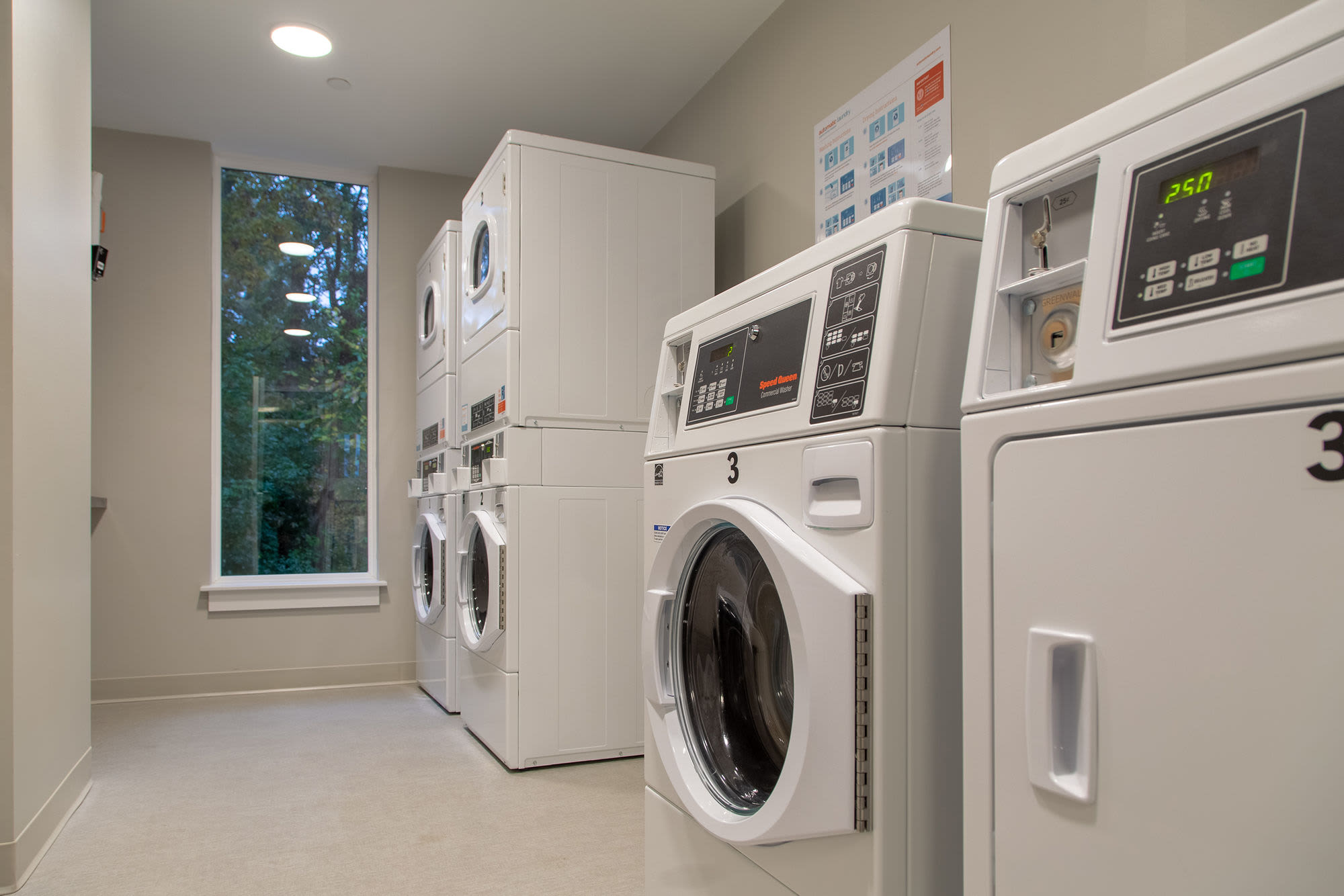 Community laundry facility with washer and dryer at Walker School Apartments in Taunton, Massachusetts
