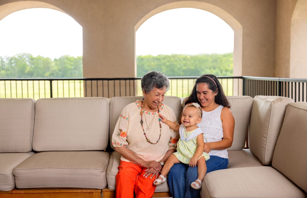 2 adult and a baby on sofa  at Glenncrest at Buckhead in Atlanta, Georgia