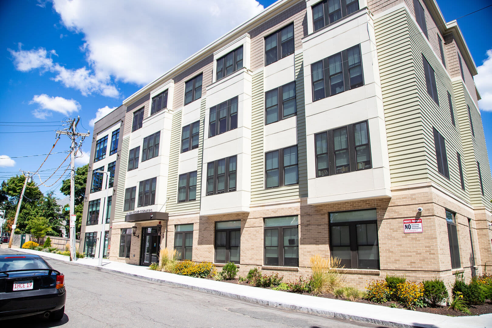 Community exterior view with driveway  at Hearth at Four Corners in Dorchester, Massachusetts