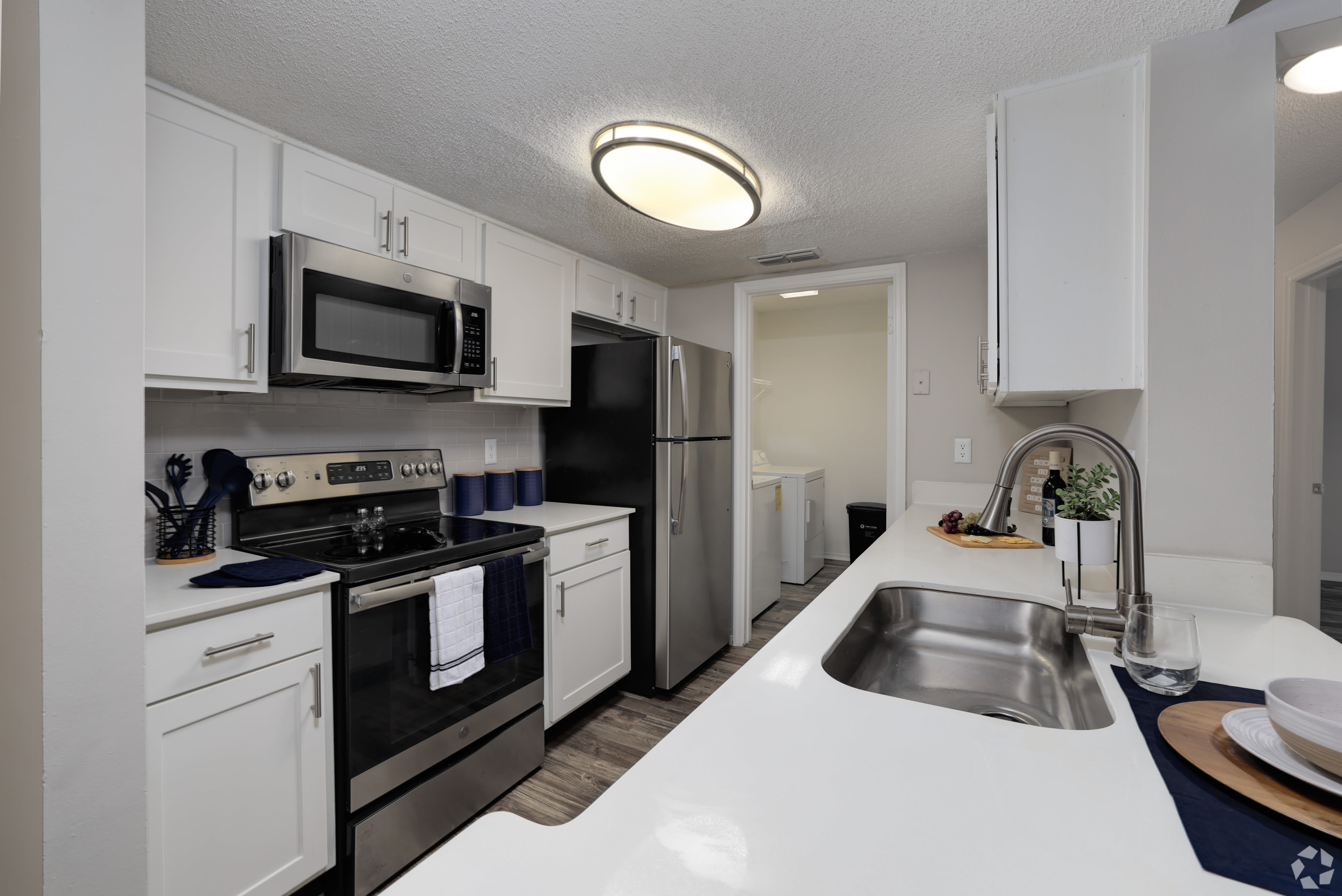 Modern kitchen with stainless steel appliances, white cabinets and a large countertop at Tuskawilla at Winter Springs in Winter Springs, Florida