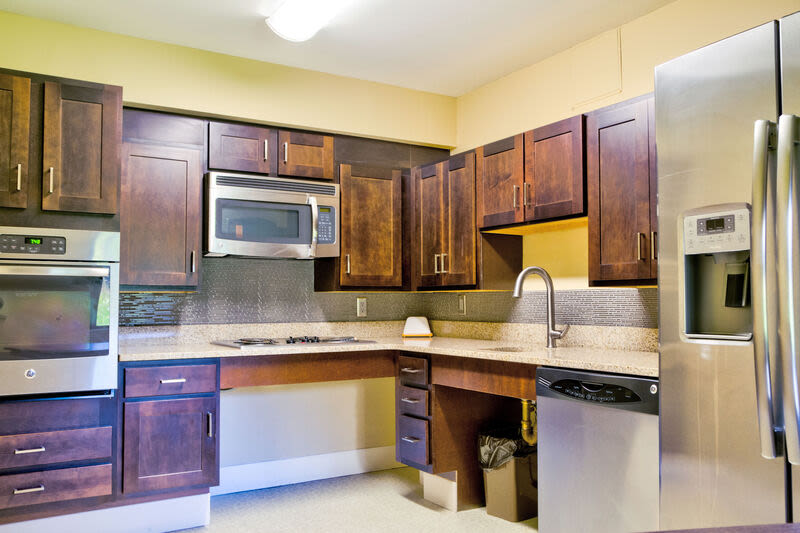 Fully equipped kitchen with appliances and wooden cabinetry at Borden Place Apartments in Fall River, Massachusetts