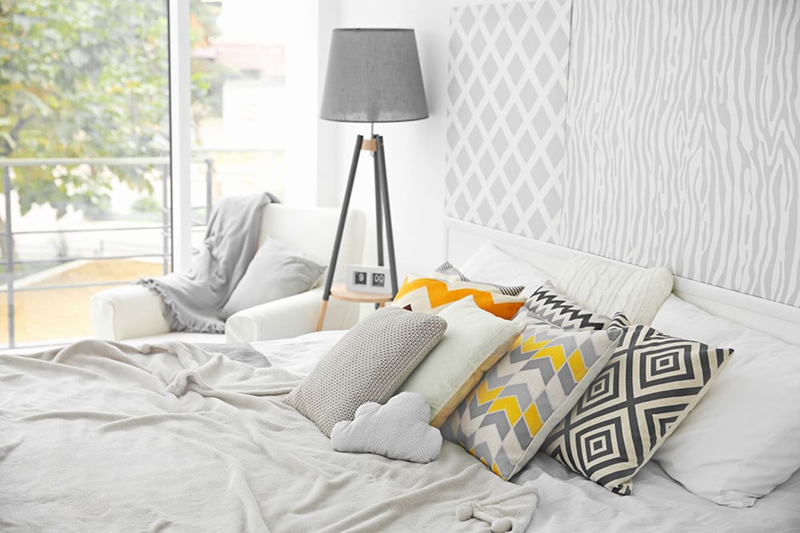 Bedroom with large comfortable bed and a lamp at Borden Place Apartments in Fall River, Massachusetts